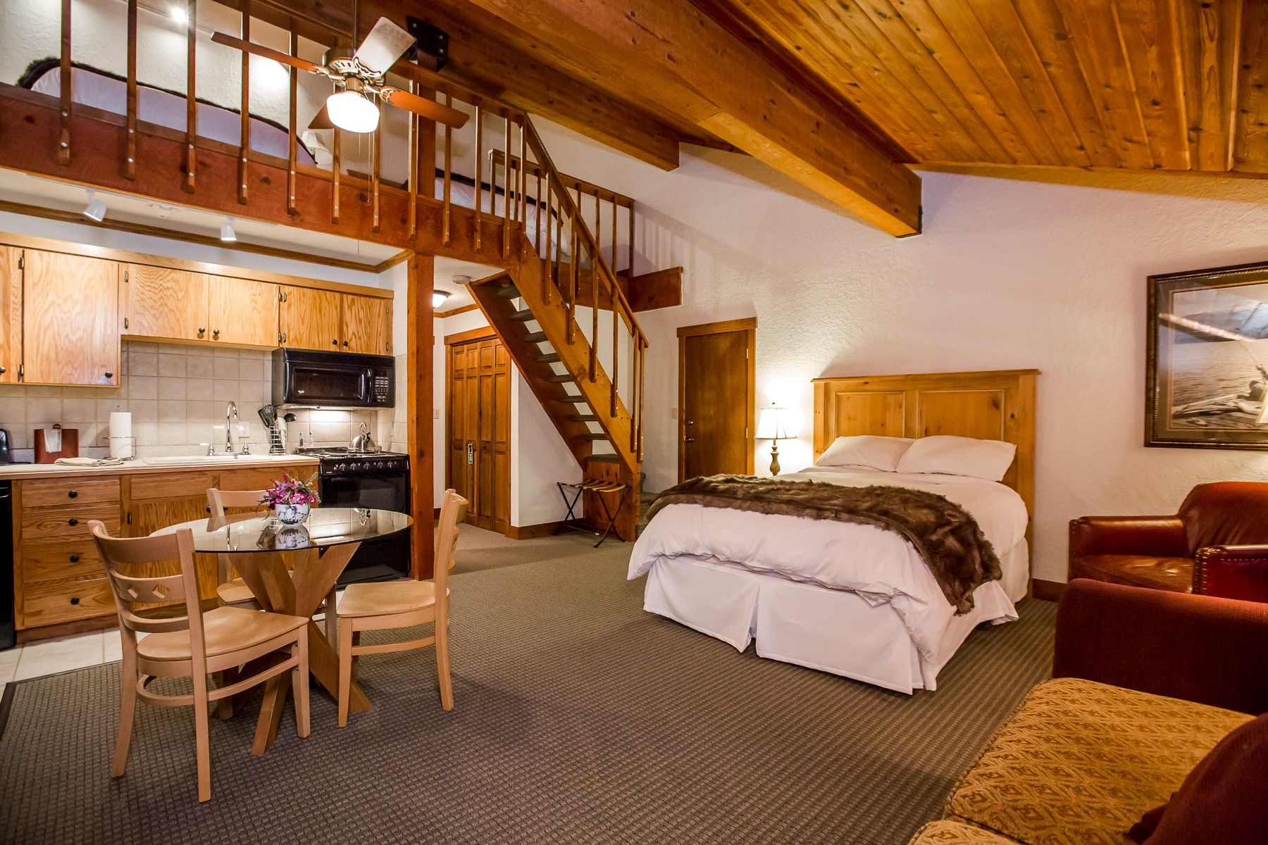 A hotel room with a king size bed and a kitchen