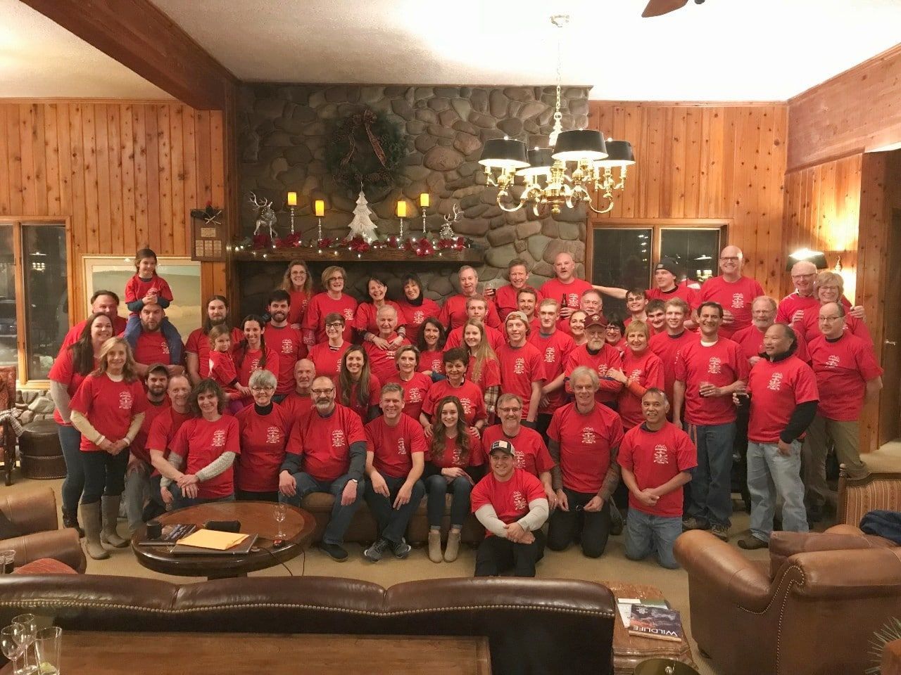 A large group of people are posing for a picture in a living room.