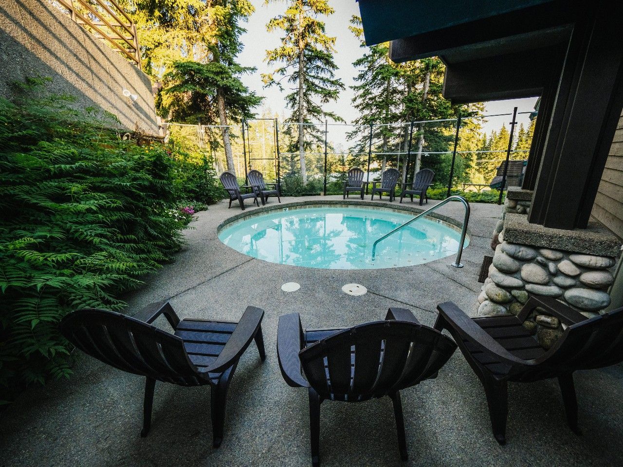 Three chairs are sitting in front of a swimming pool.