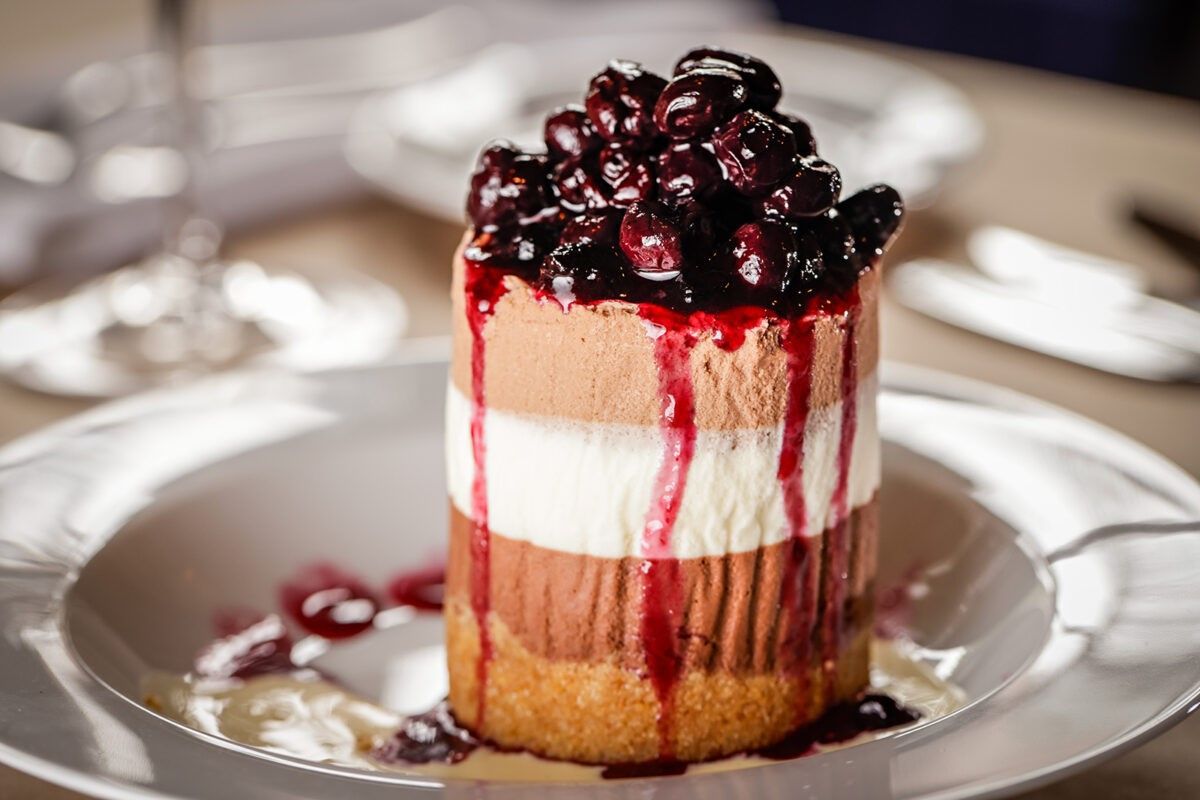 A bar with a lot of wine glasses hanging from the ceiling