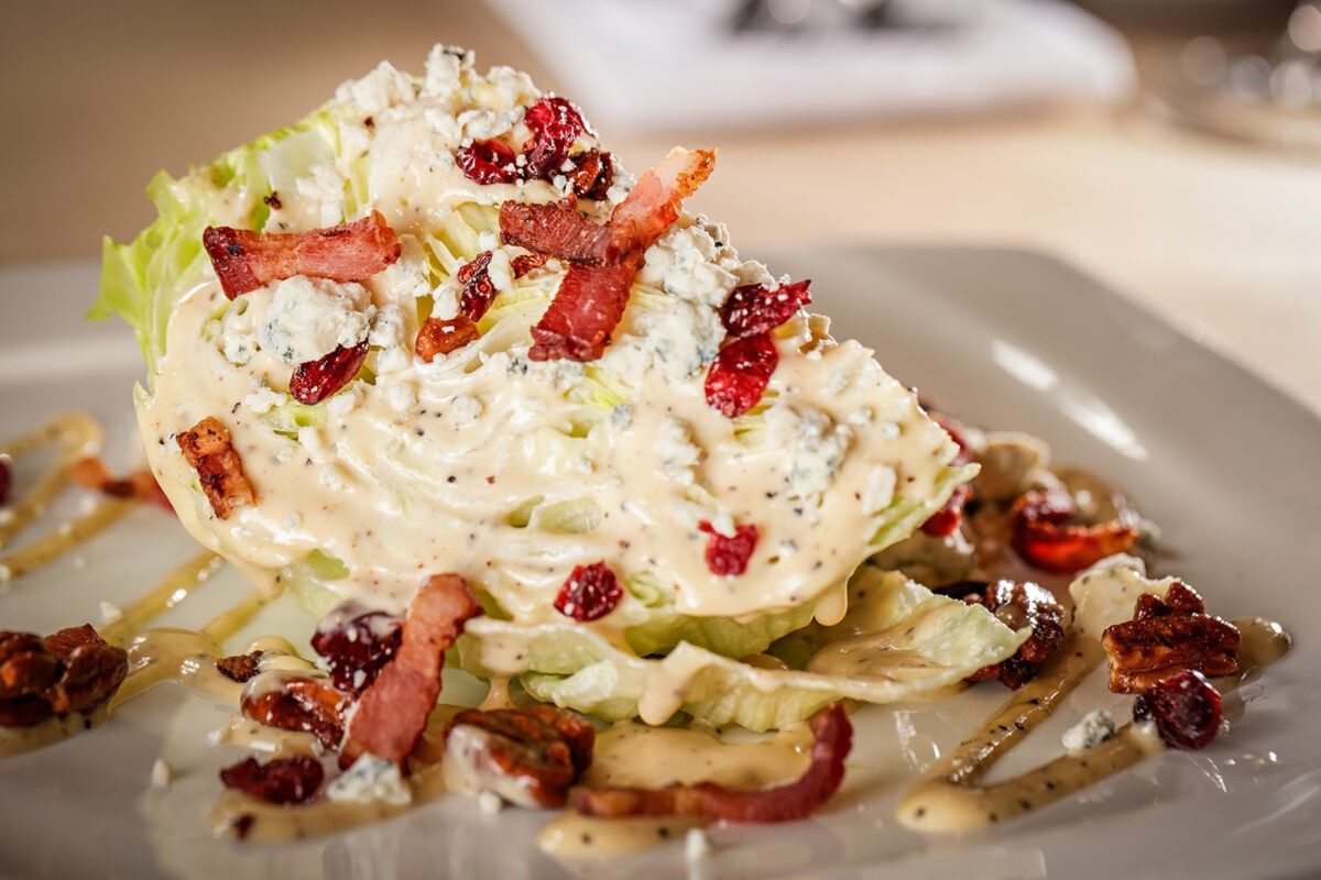A glass of whiskey with ice cubes on a wooden table.