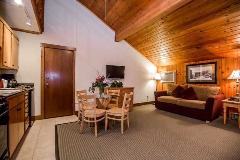 A living room with a couch , table , chairs and a television.
