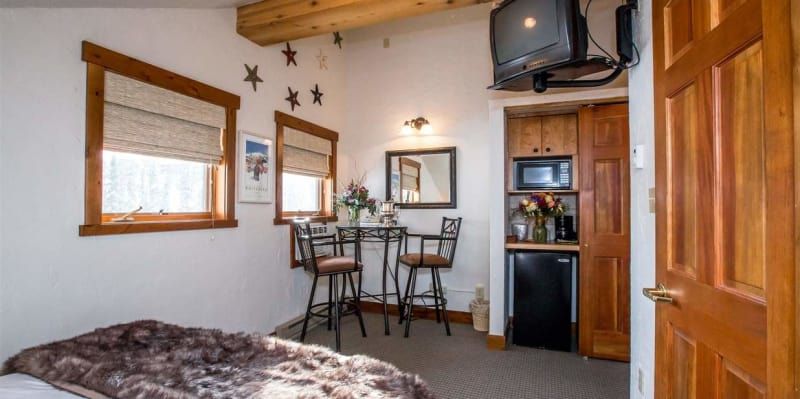 A bedroom with a bed , television , table and chairs.
