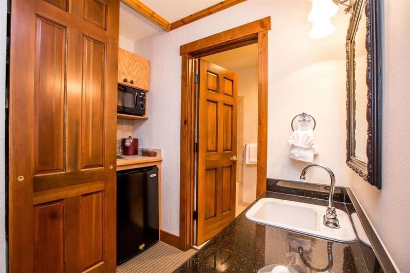 A bathroom with a sink , mirror and microwave.