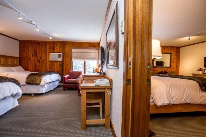 A hotel room with two beds , a desk and a chair.