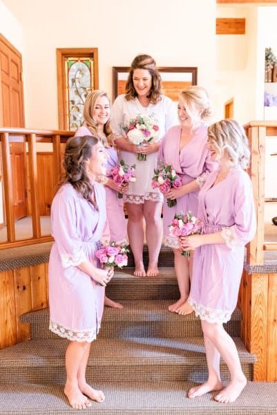 A bride and her bridesmaids are posing for a picture on the stairs.