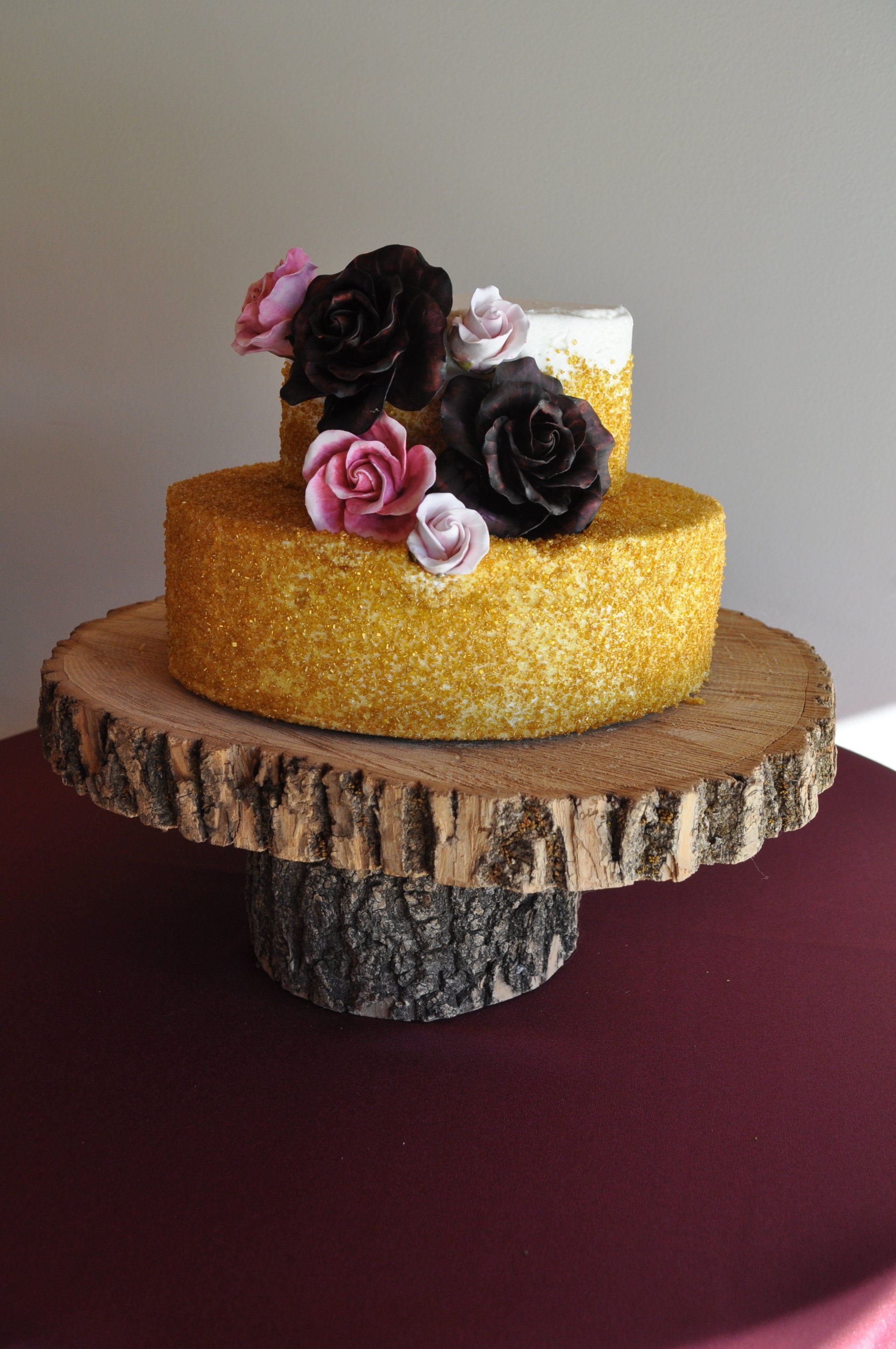 A cake is sitting on top of a wooden cake stand.