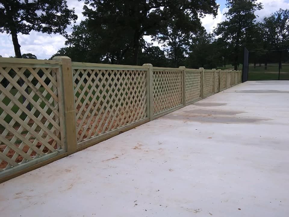 A wooden lattice fence along a concrete walkway