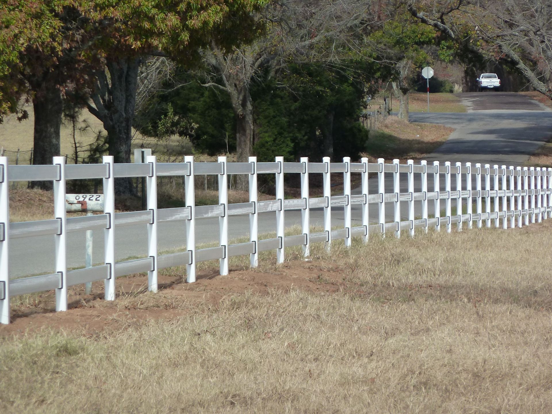 A white fence along the side of a road