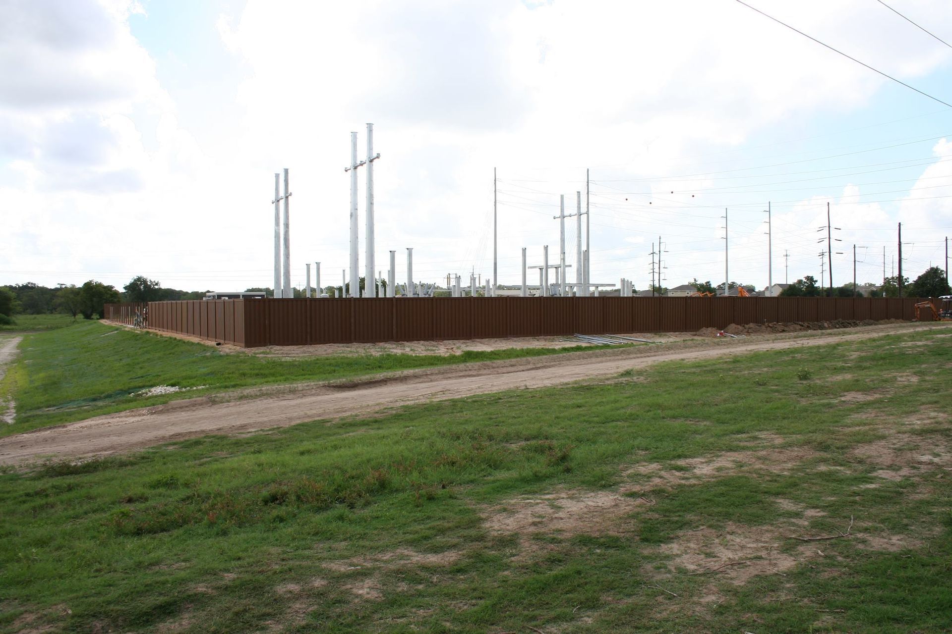 A fenced in area with a lot of power lines in the background.