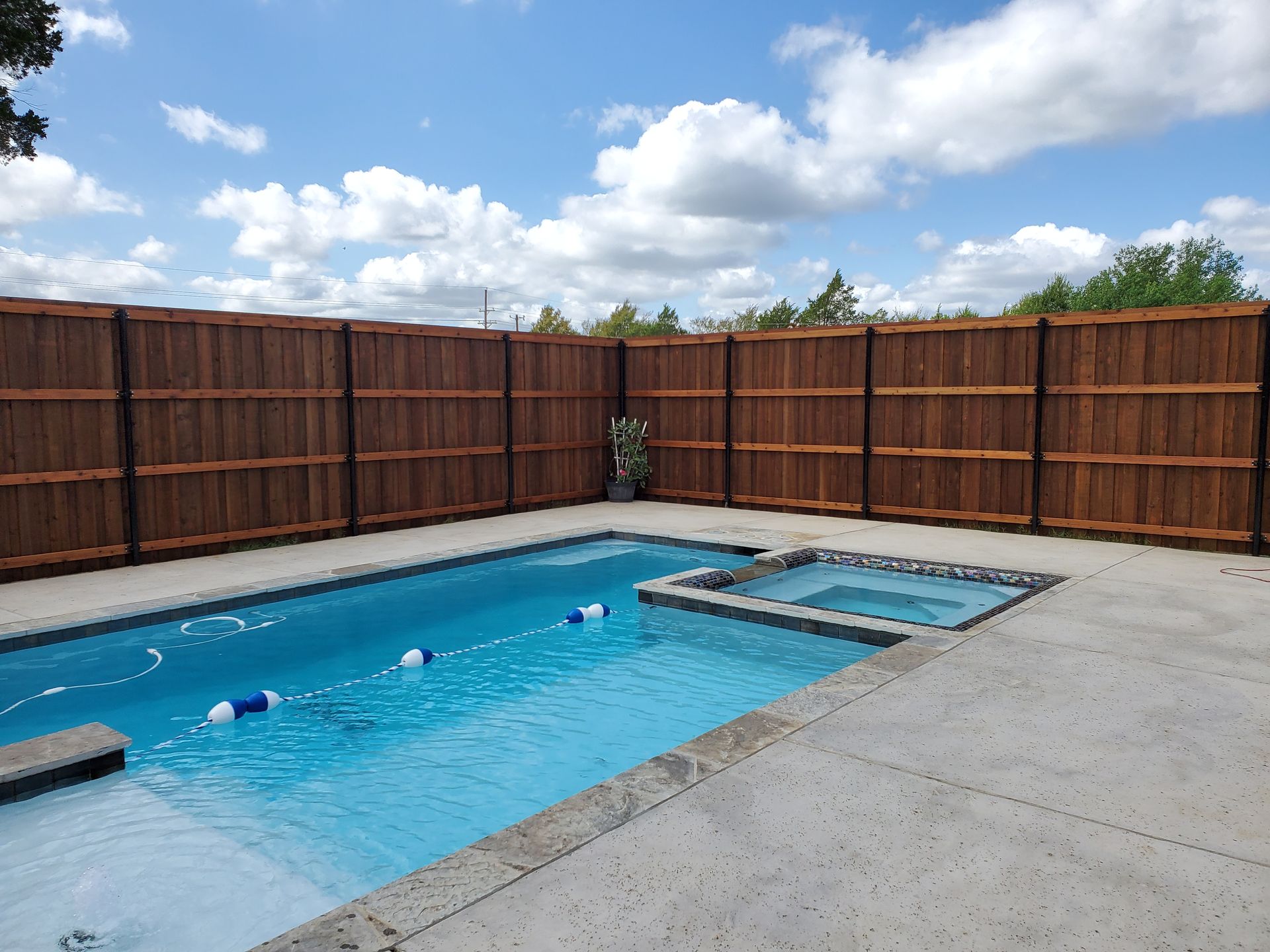 A large swimming pool with a wooden fence surrounding it.