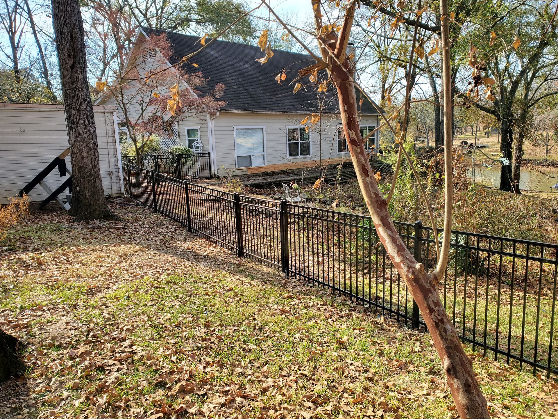 A white house with a black fence in front of it.