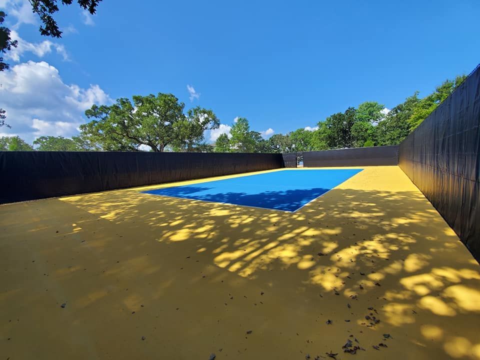 A blue and yellow pool with a black fence surrounding it.