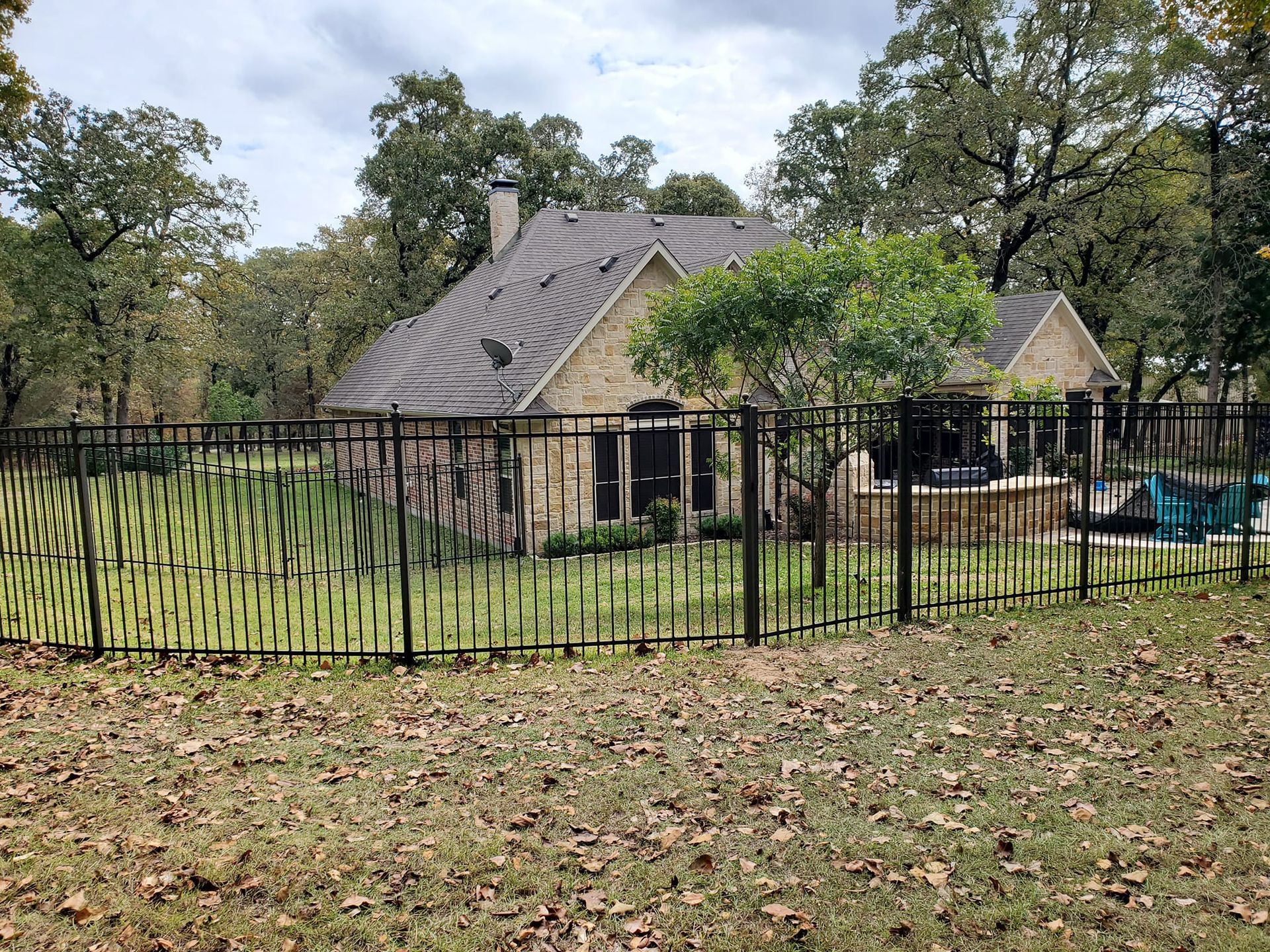 A house with a fence around it and a pool in the backyard.