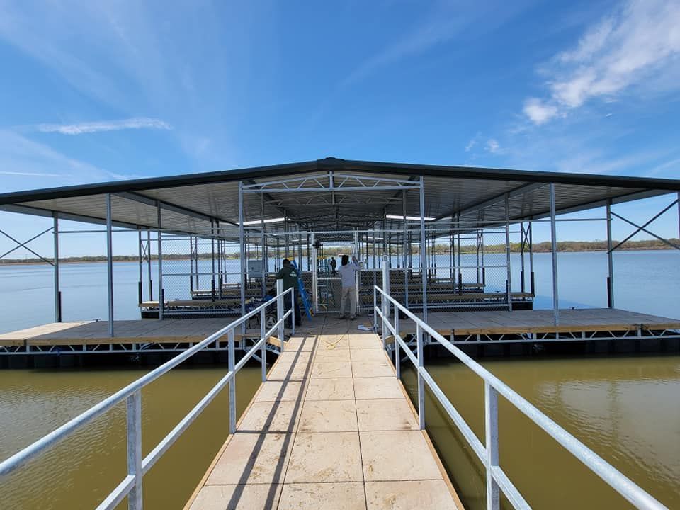 A dock with a railing leading to a large body of water.