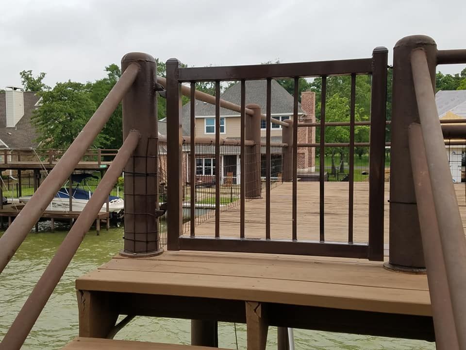 A wooden dock with a gate leading to a house
