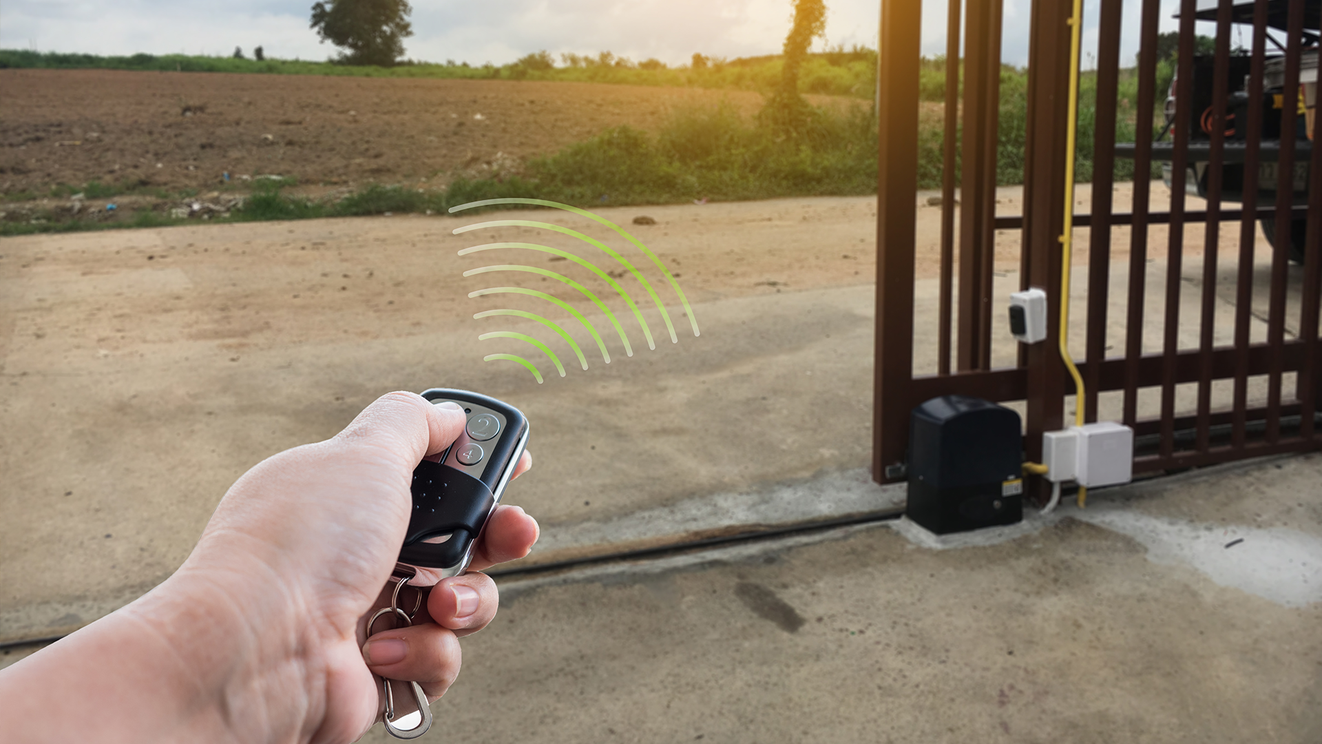 A person is using a remote control to open a gate.