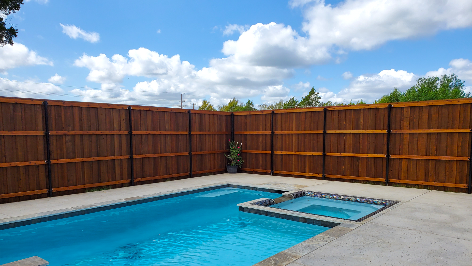A large swimming pool with a wooden fence surrounding it.