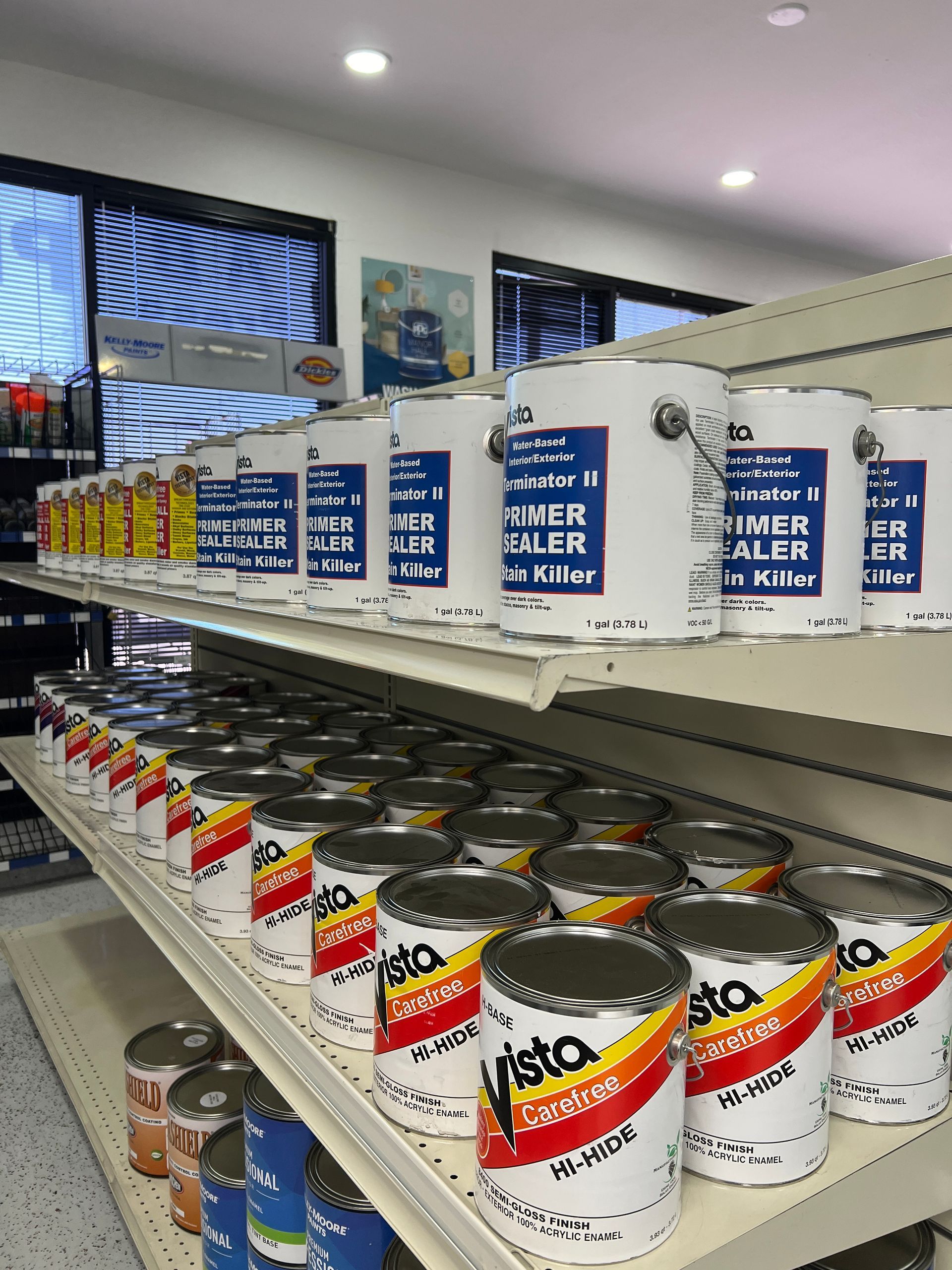 A store shelf filled with lots of cans of paint