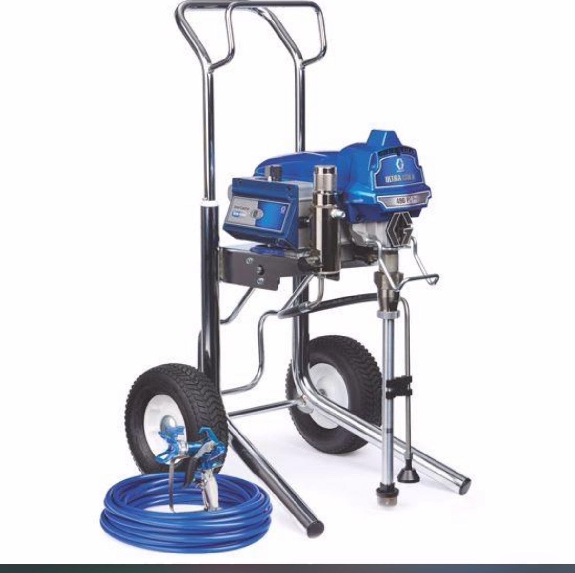 A spray paint machine is sitting on a cart with a hose attached to it.