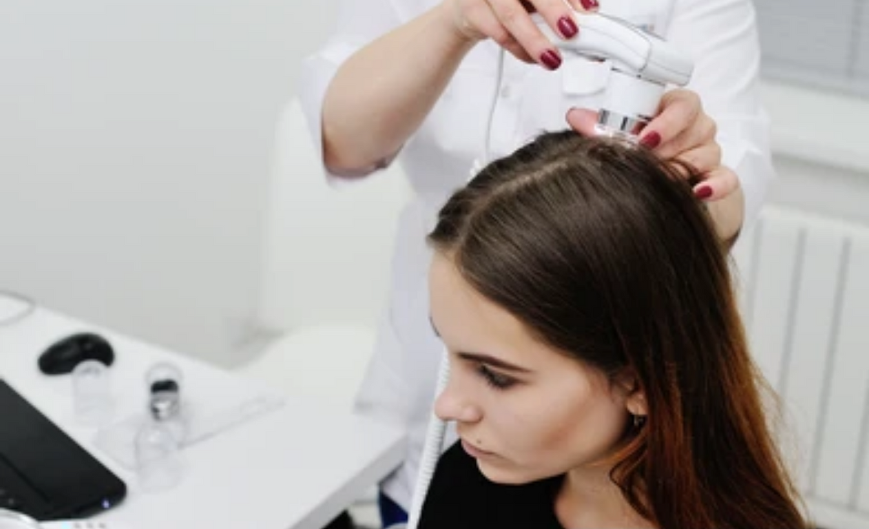 A trichologist examining a patient's hair and scalp during an early intervention for hair loss