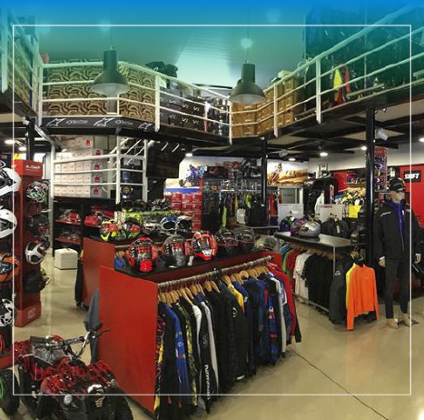 Interior de una tienda de artículos para motocicletas con cascos, chaquetas y accesorios en exhibición.