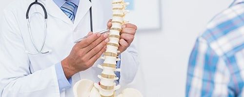 Chiropractic Service — Doctor Showing Anatomic Spine To Patient in Kidron, OH