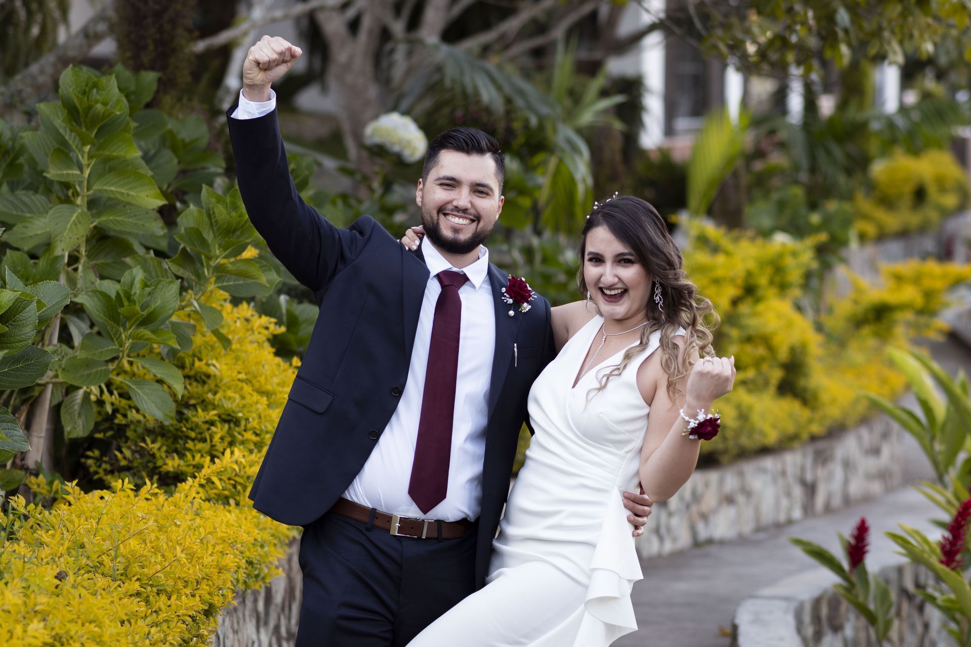 Una novia y un novio posan para una foto en un jardín.