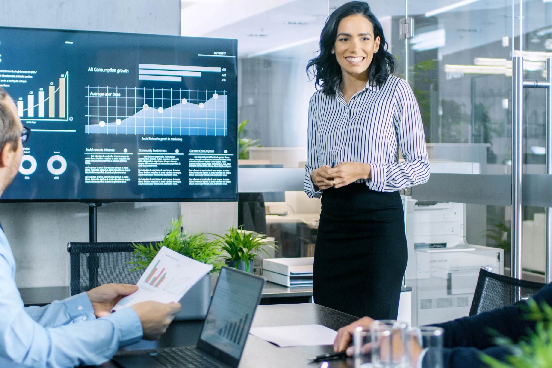 Una mujer está dando una presentación a un grupo de personas en una oficina.