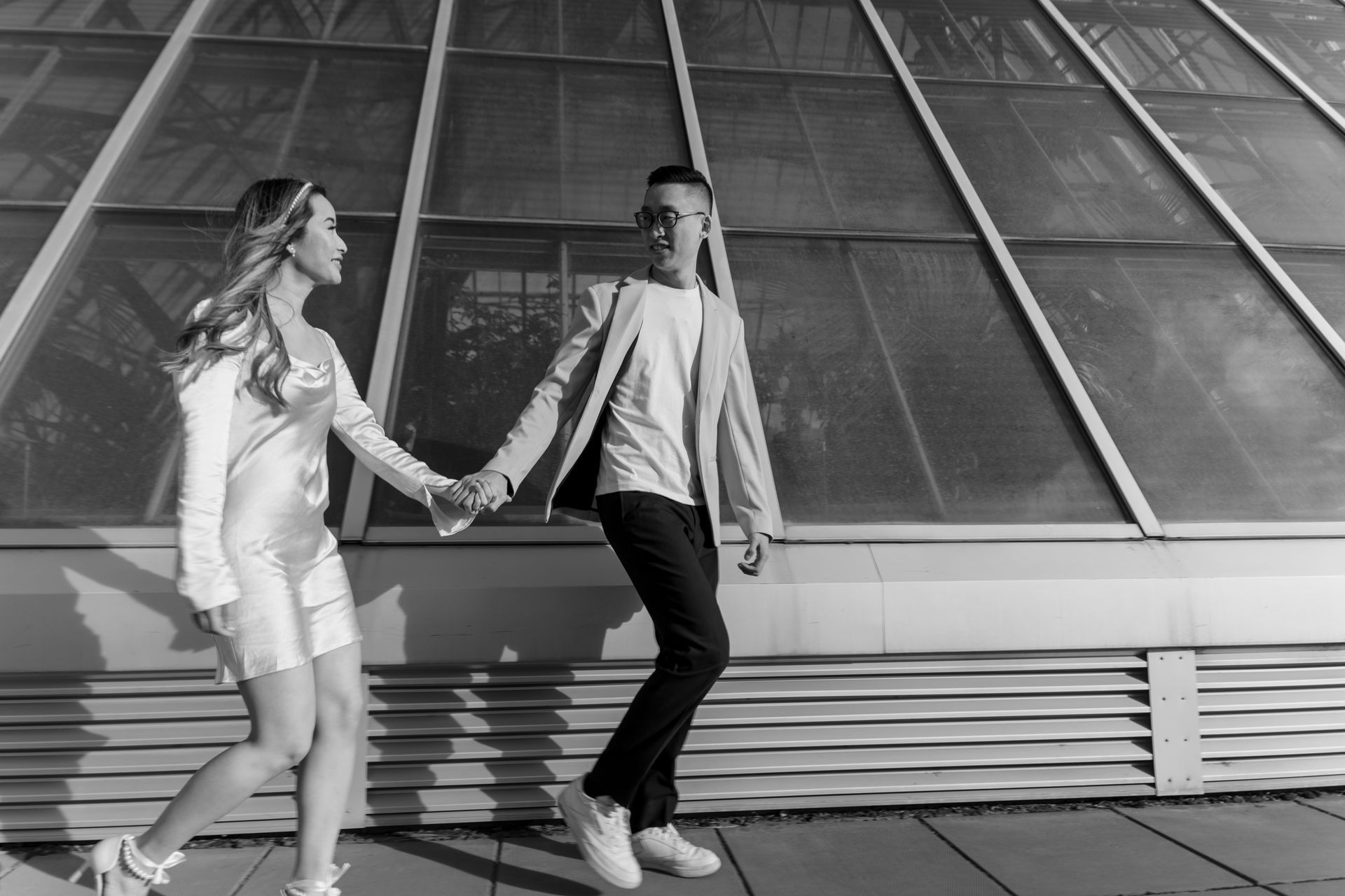 A black and white photo of a man and woman holding hands.