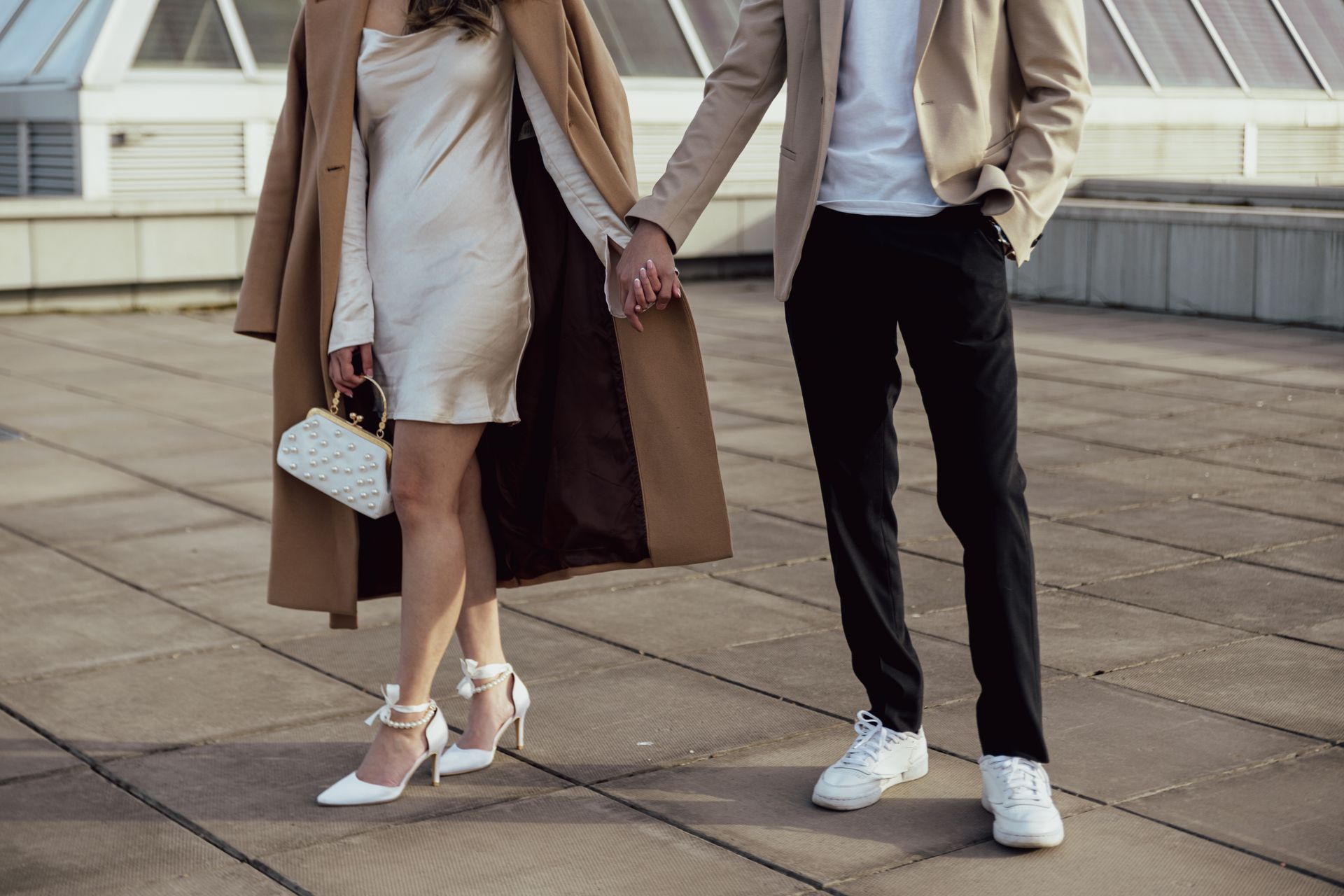A man and a woman are holding hands on a rooftop.