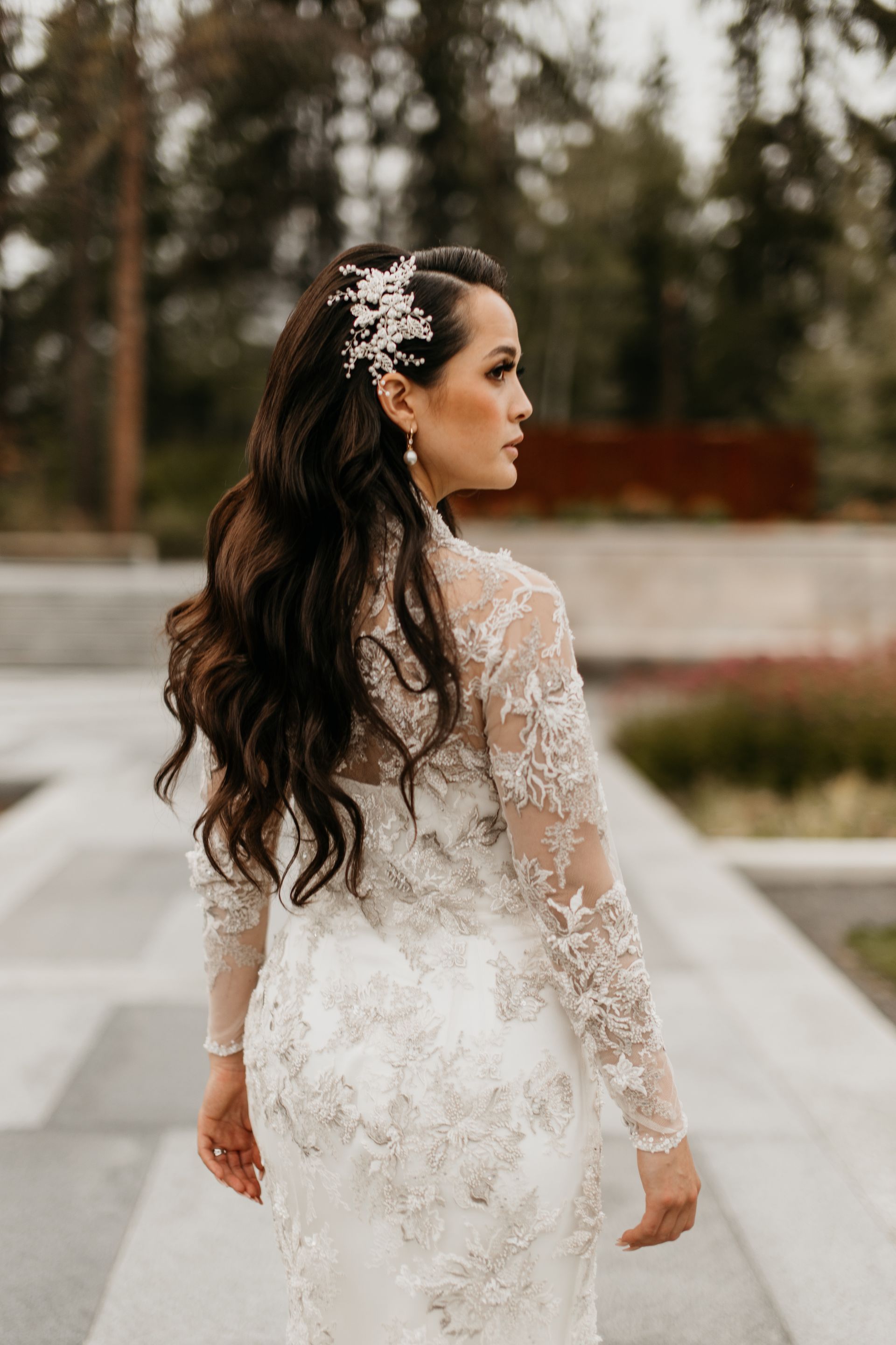 A woman in a wedding dress is standing on a sidewalk.
