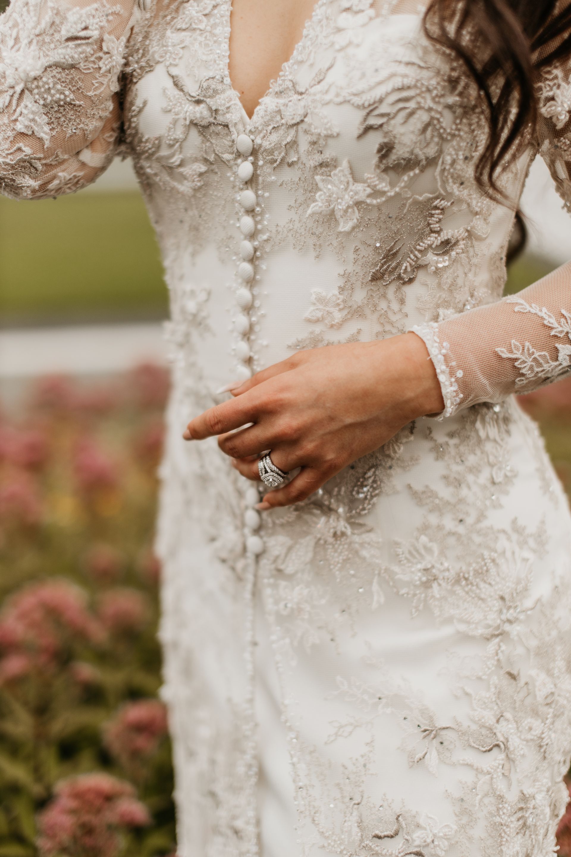 The bride is wearing a wedding dress and a diamond ring.