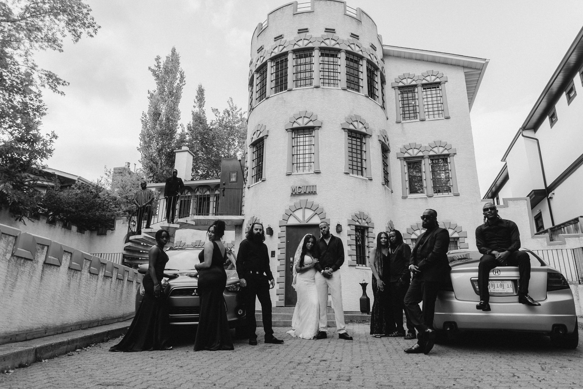 A black and white photo of a group of people standing in front of a building.