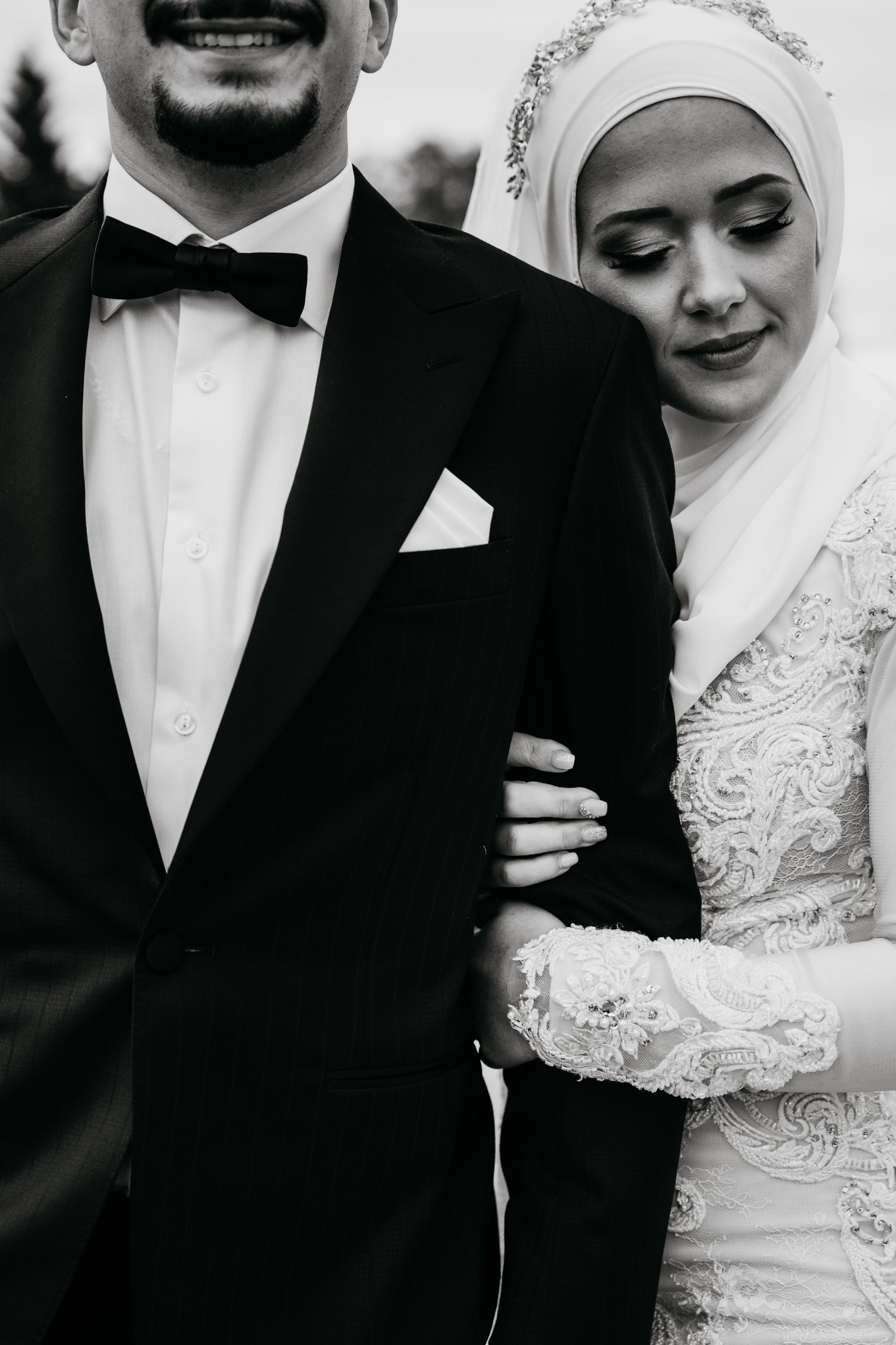 A black and white photo of a bride and groom standing next to each other.