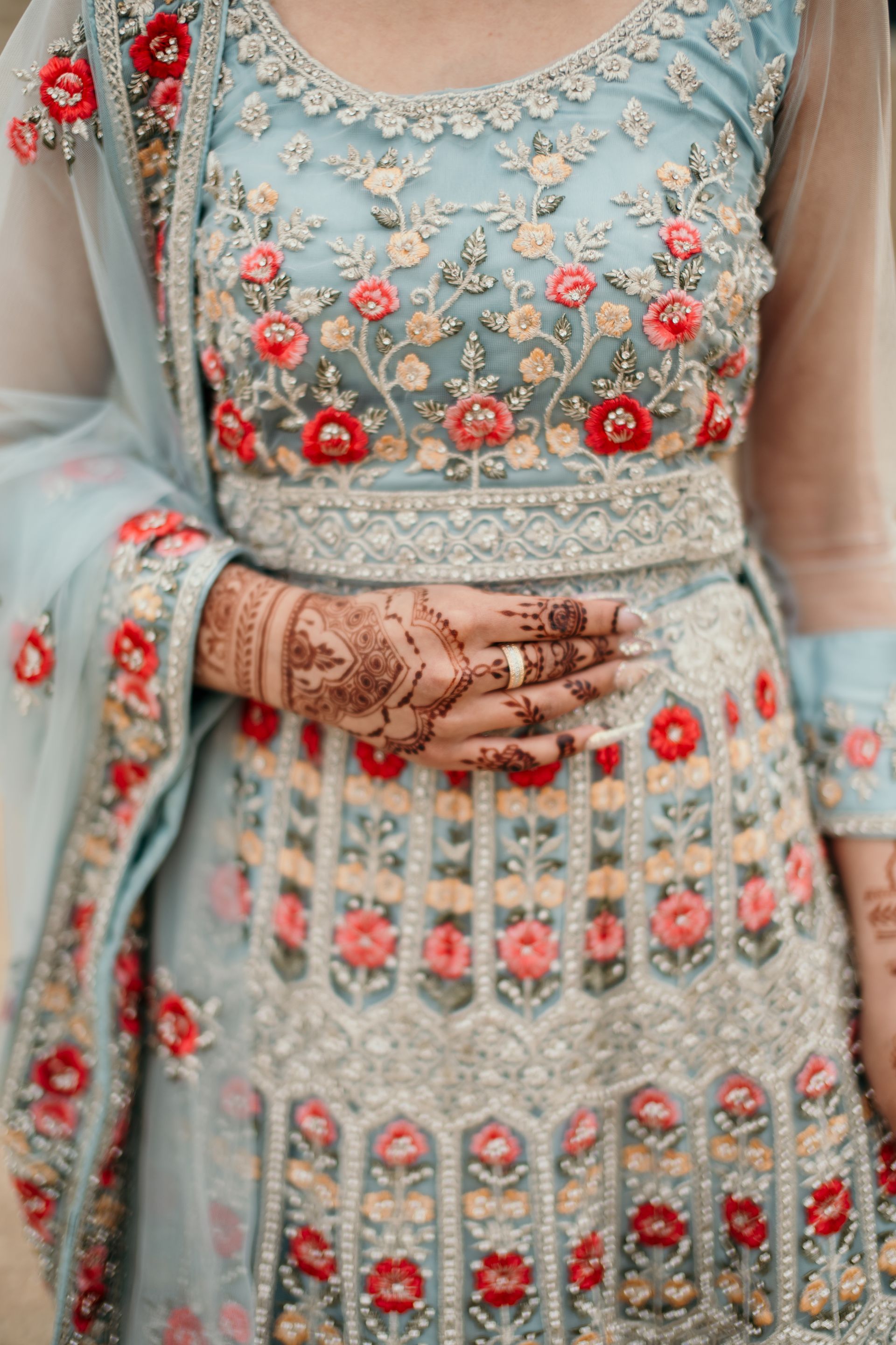 A woman in a blue and white dress with henna on her hands.