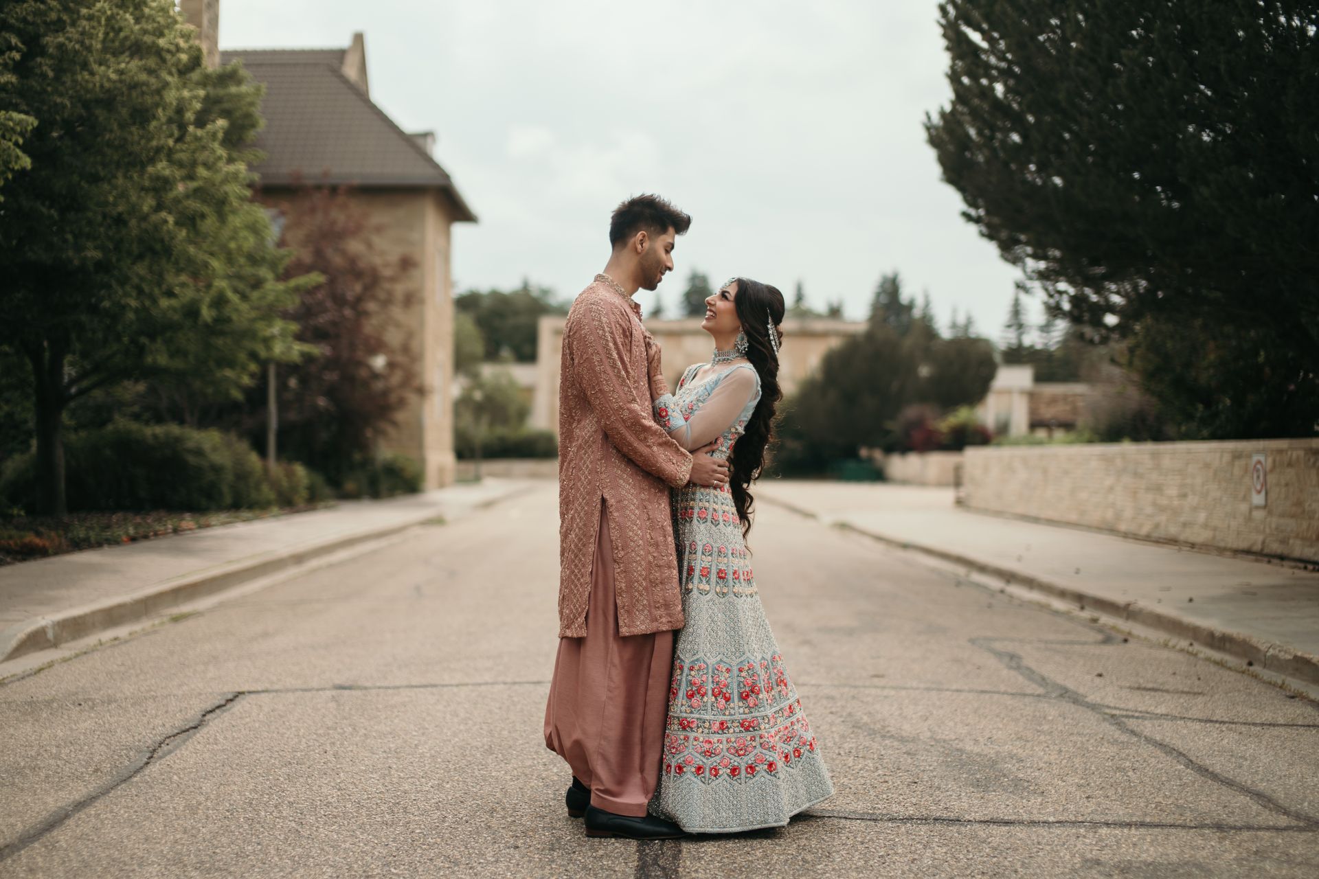 A man and a woman are standing next to each other on the side of a road.