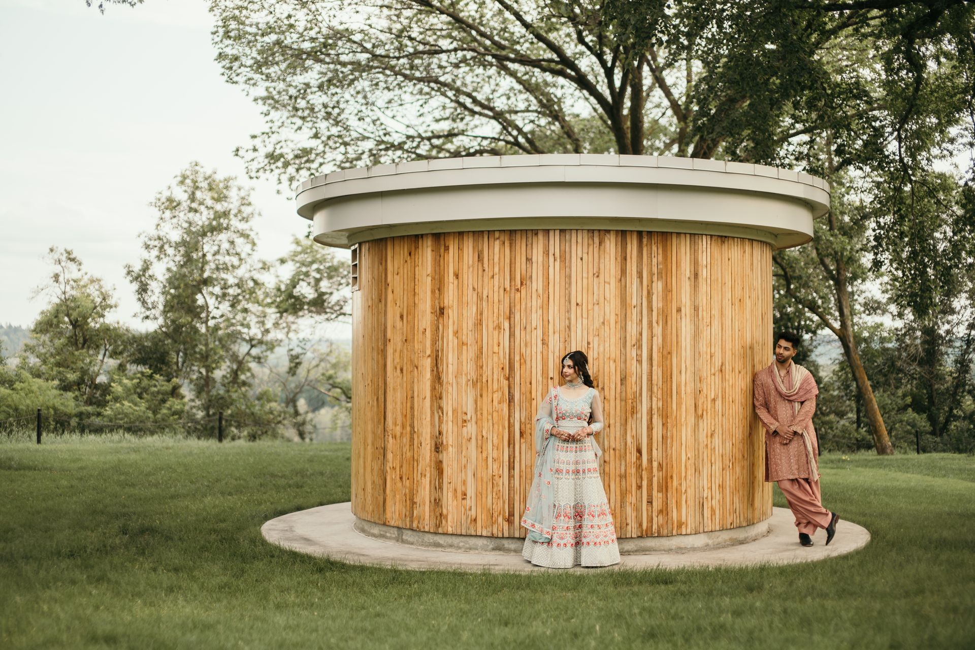 A man and a woman are standing in front of a wooden building.