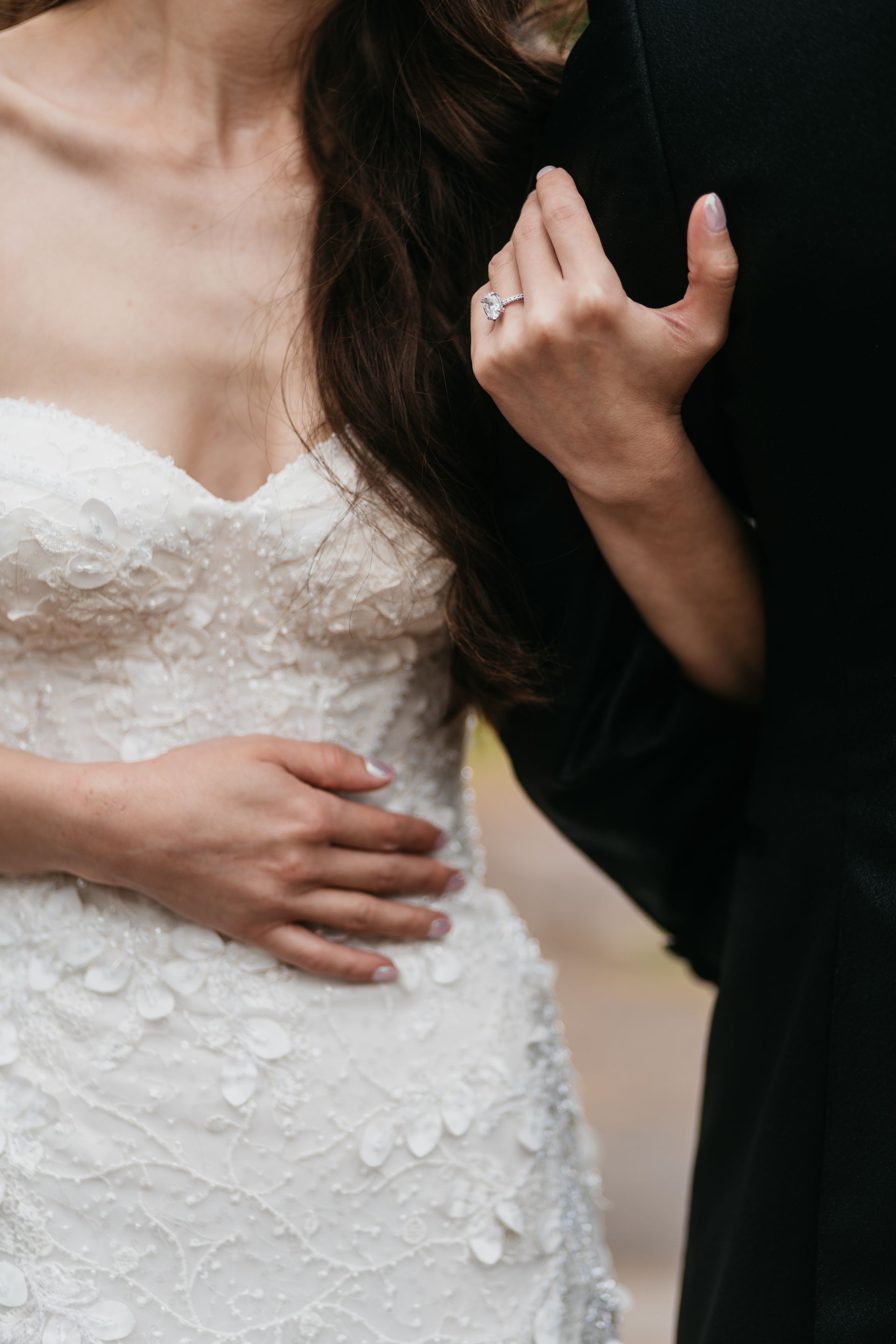 The bride is wearing a wedding dress and the groom is wearing a black suit.