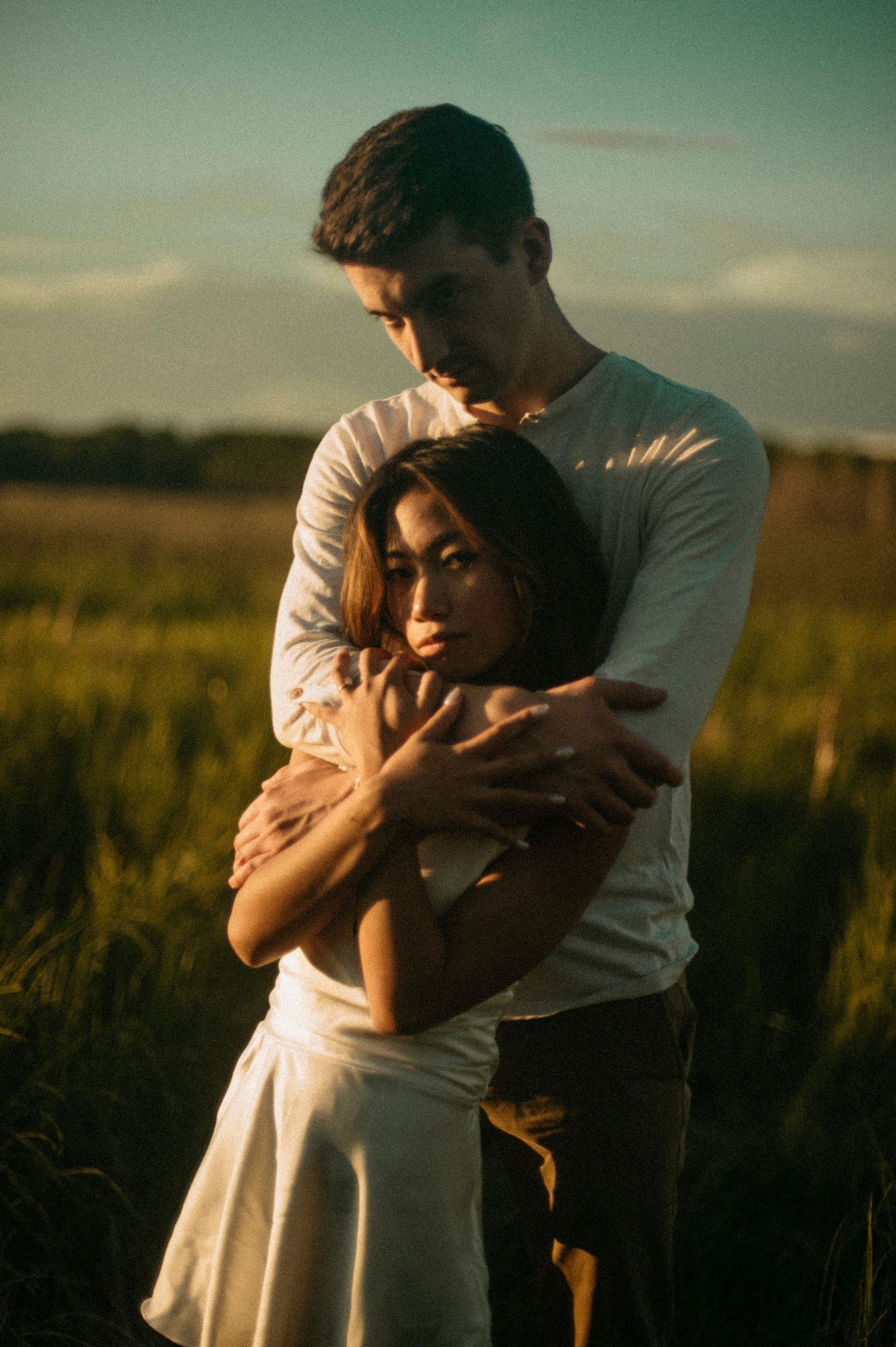 A man is hugging a woman in a field.