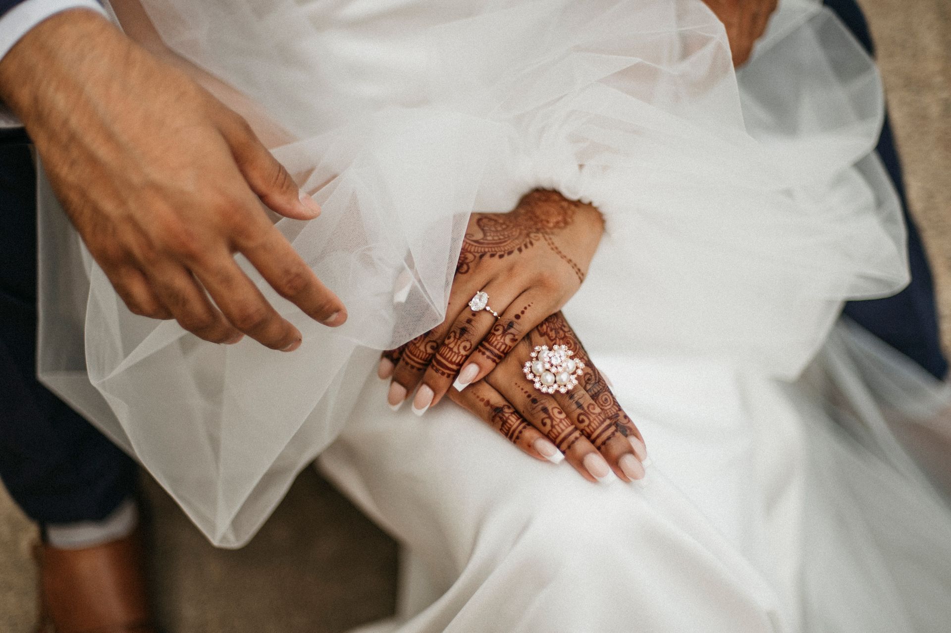 A close up of a bride and groom 's hands with rings on them.