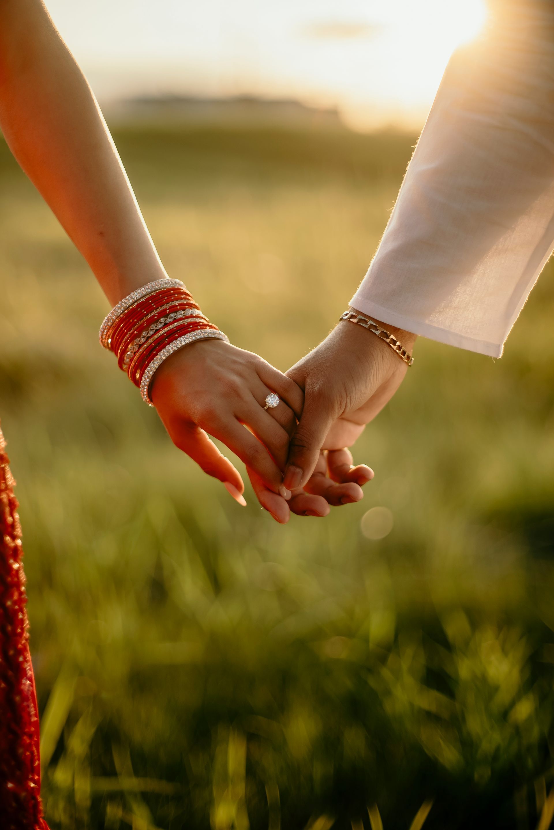 A man and a woman are holding hands in a field.