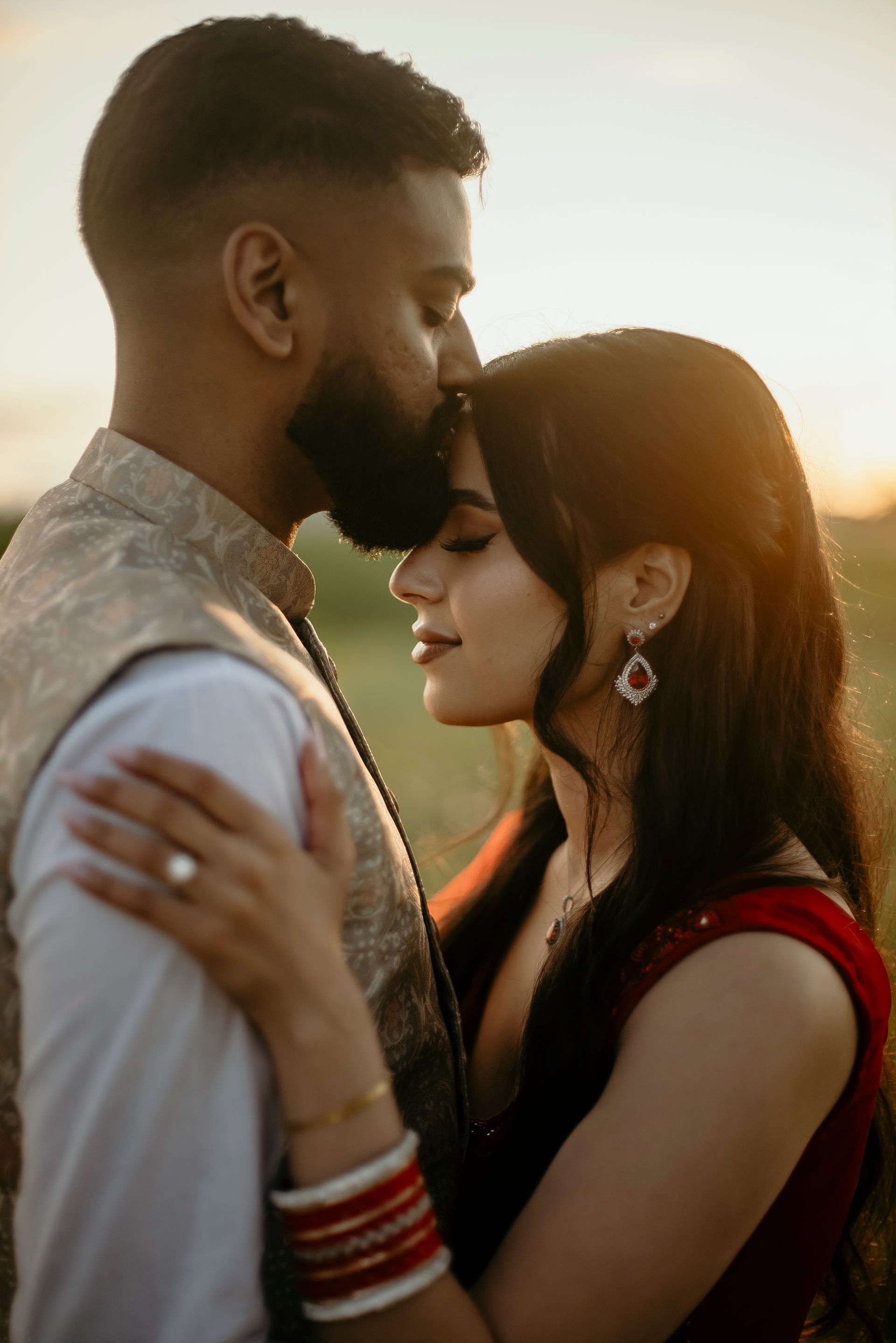 A man and a woman are hugging each other in a field.