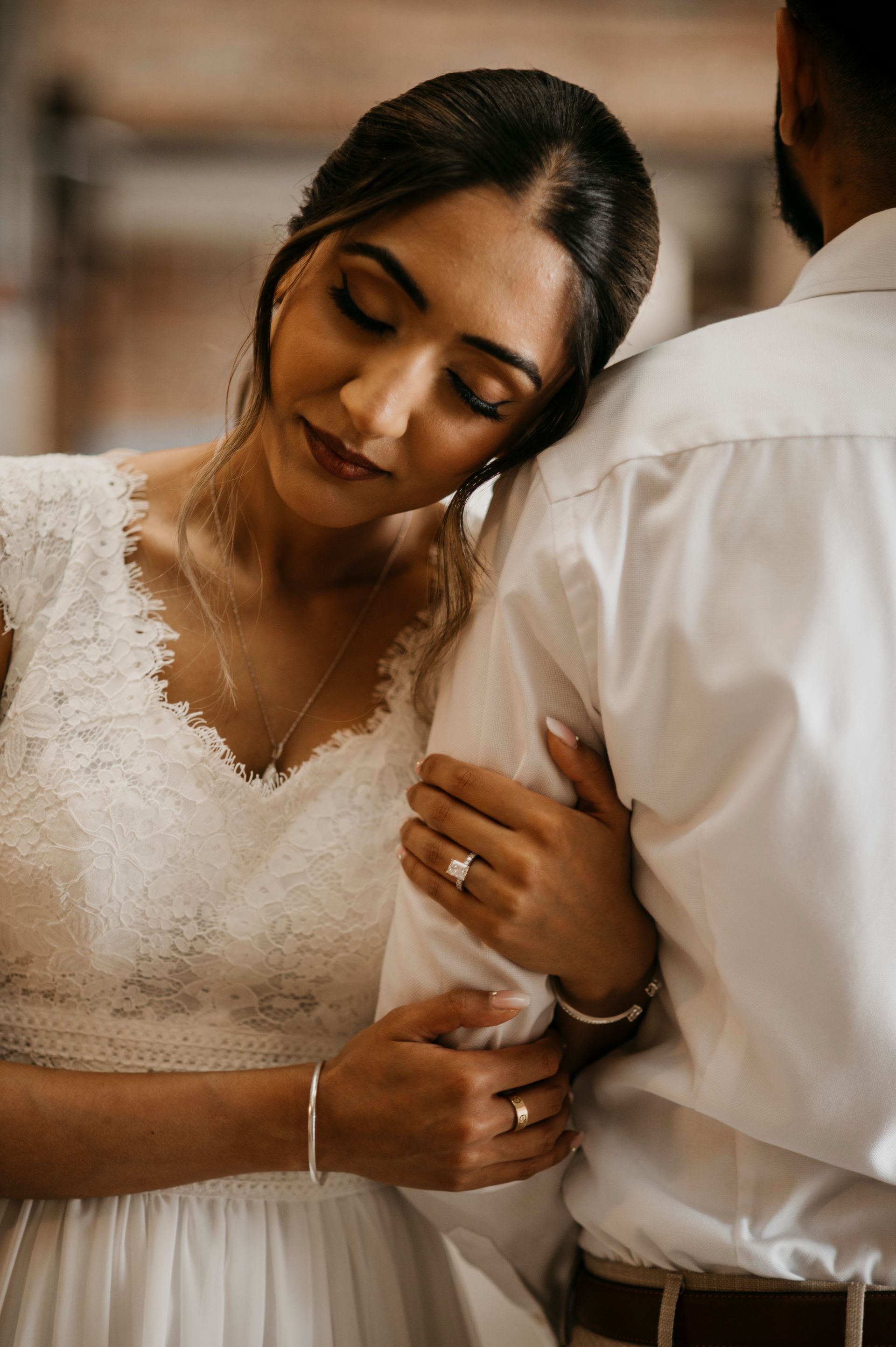 A woman in a wedding dress is hugging a man in a white shirt.