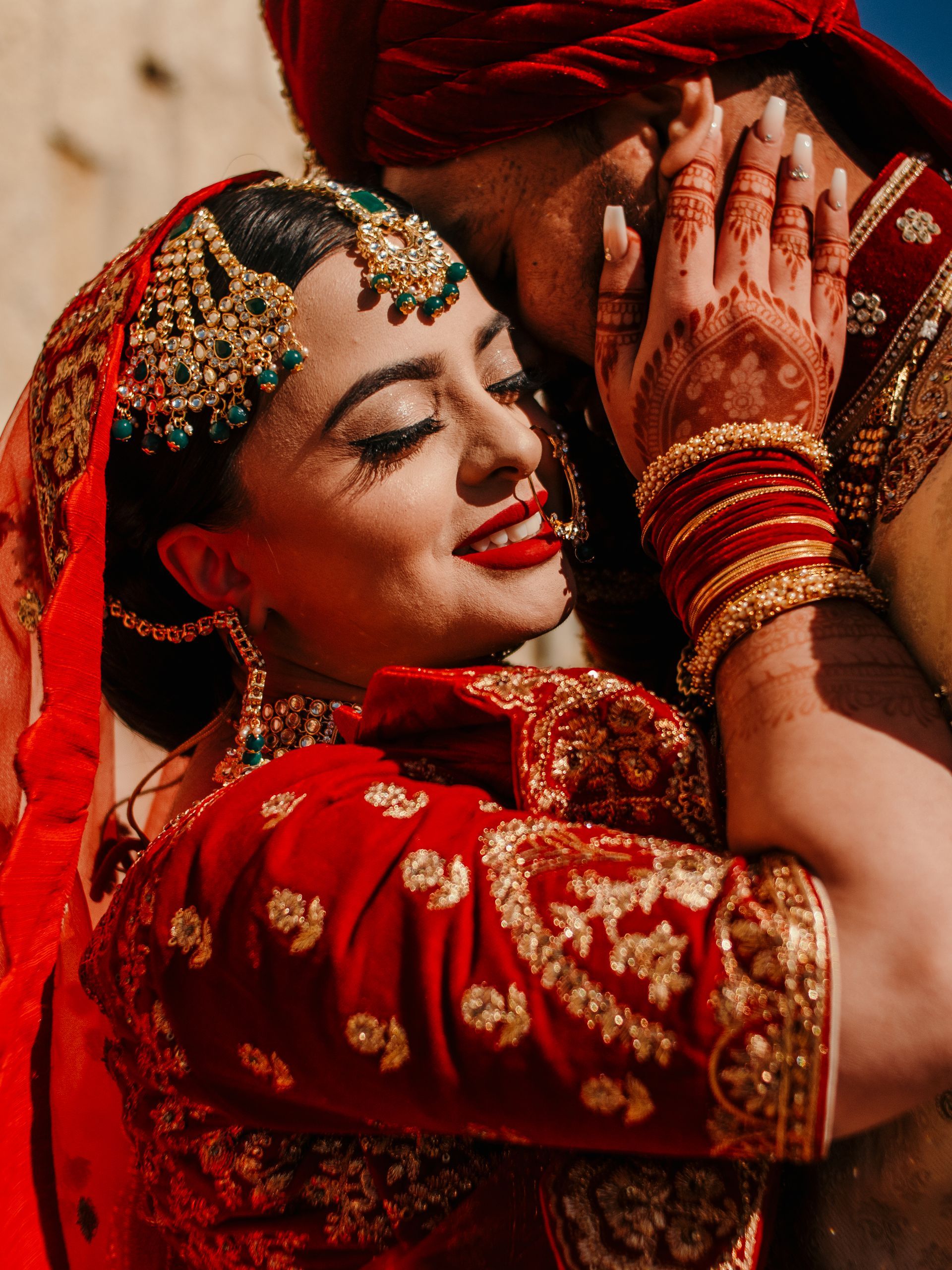 A bride and groom are hugging each other on their wedding day.