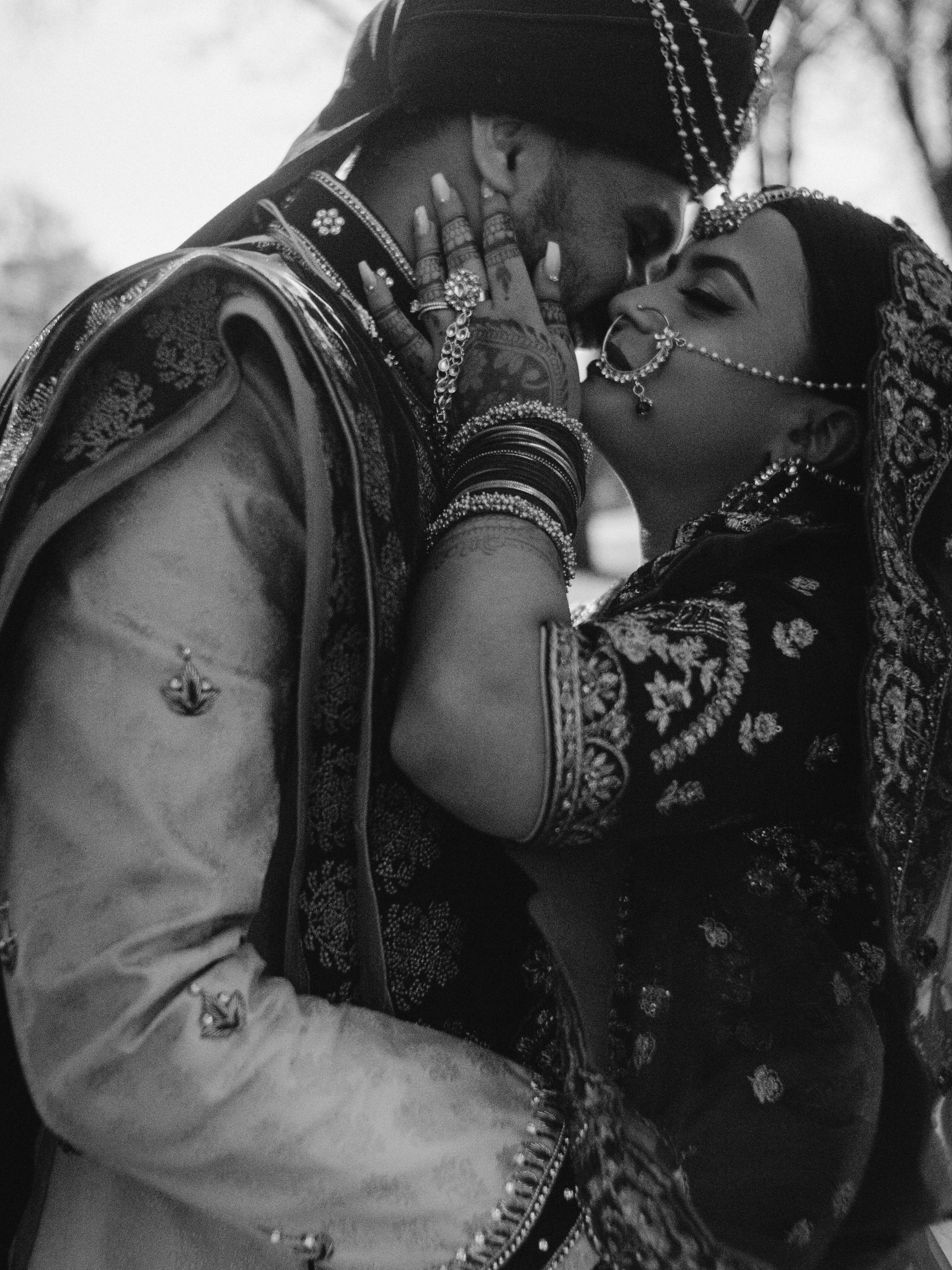 A bride and groom kissing in a black and white photo
