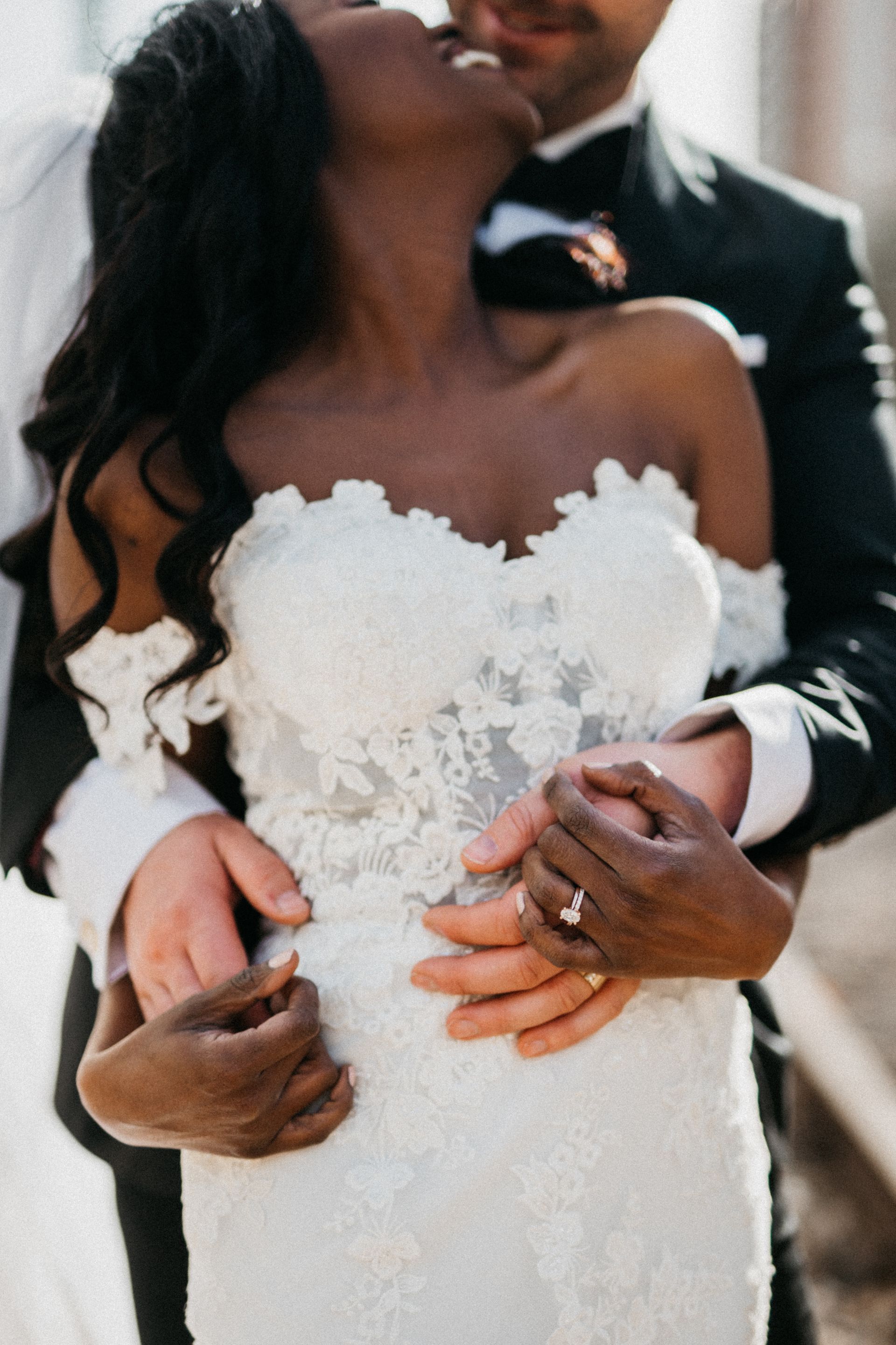 A bride and groom are kissing and the bride is wearing a wedding dress.