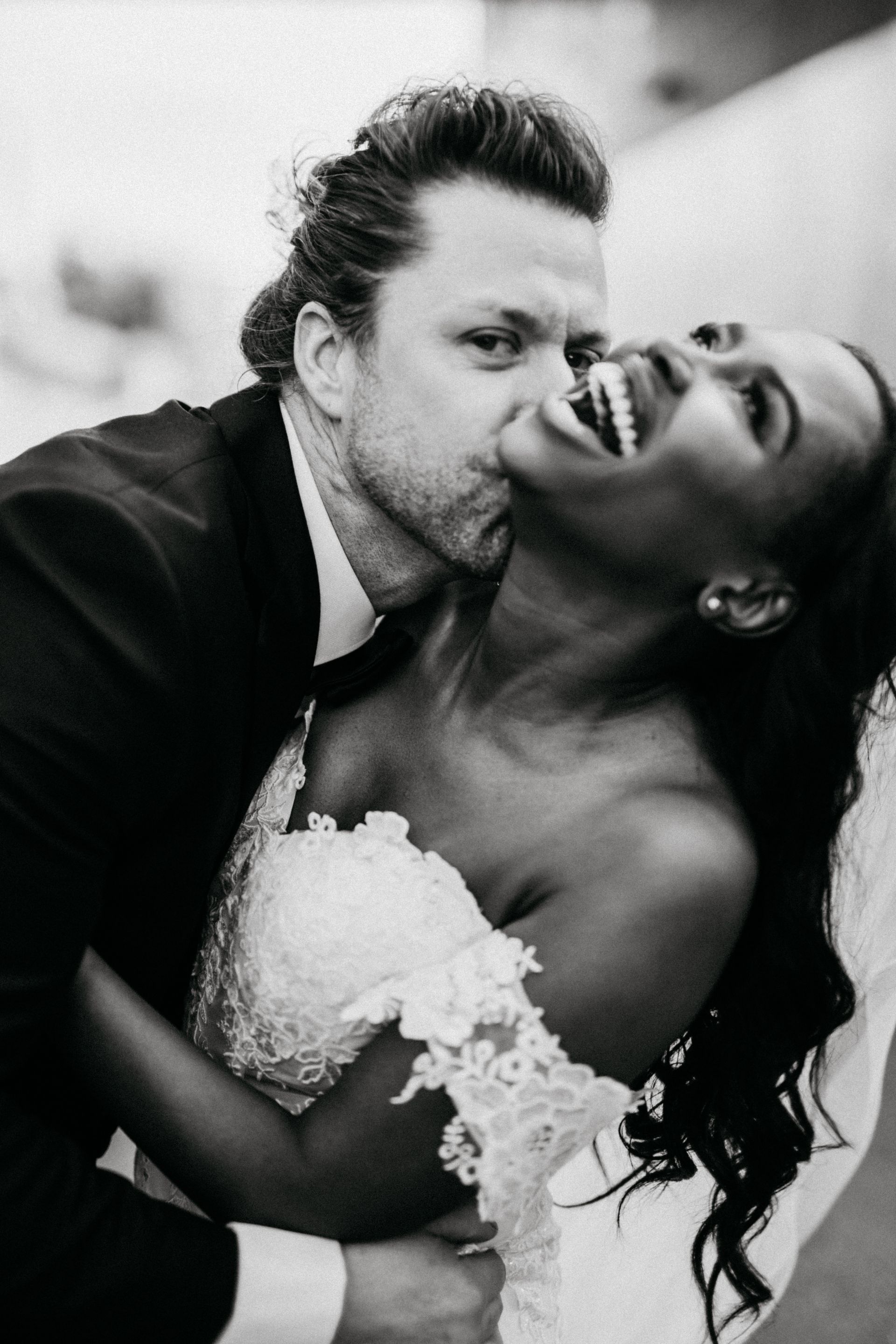 A bride and groom are posing for a black and white photo.