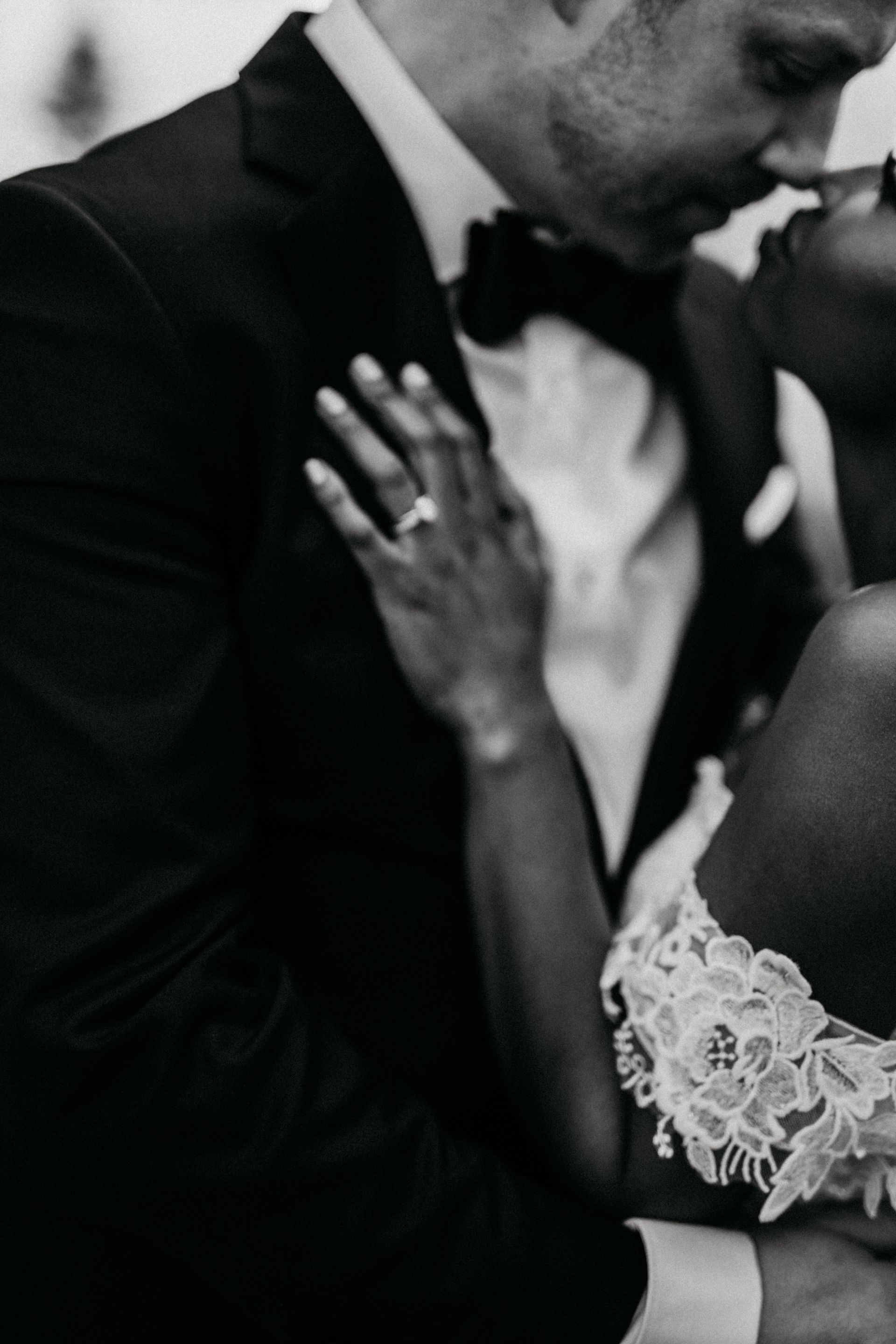 A black and white photo of a bride and groom kissing on their wedding day.