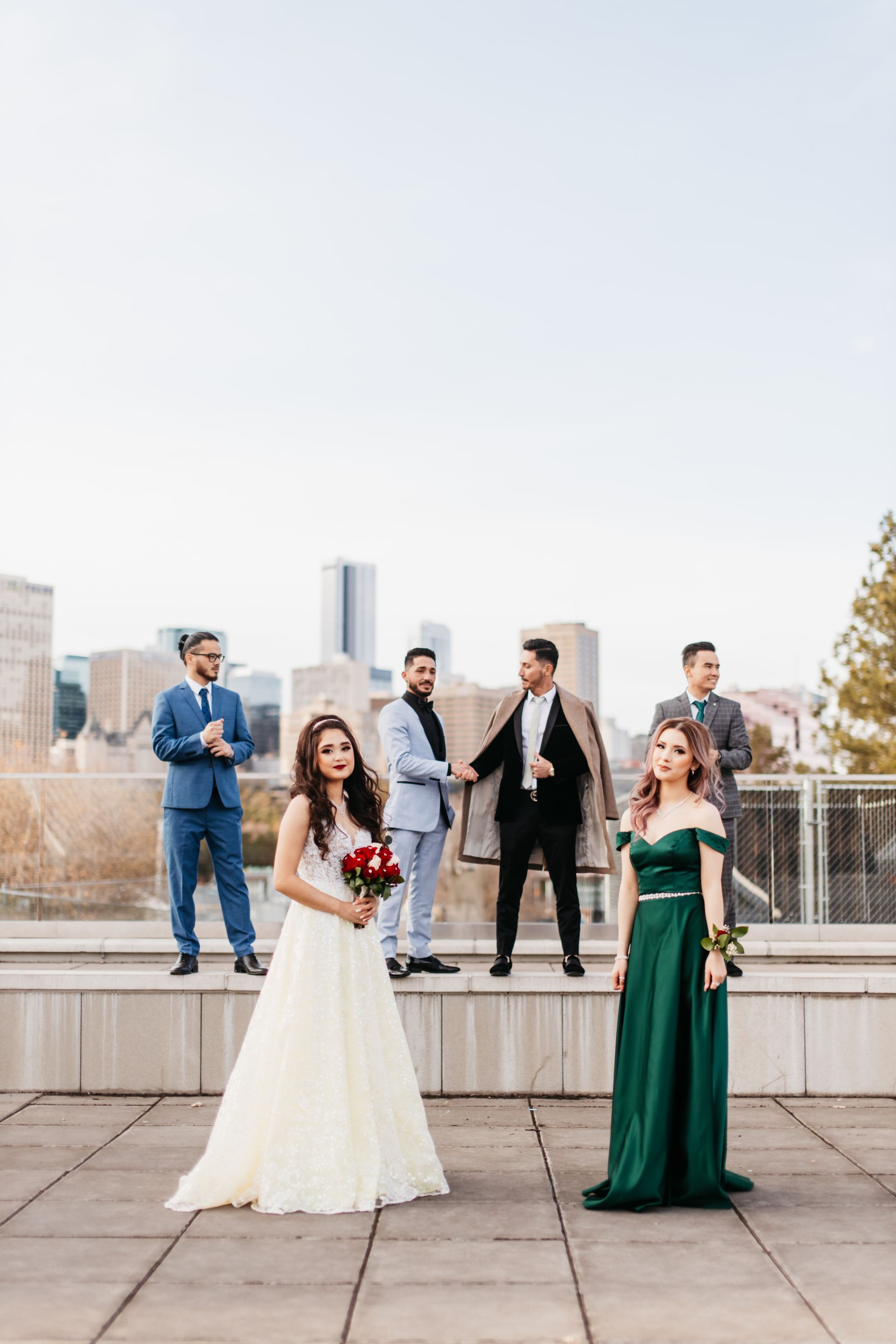 A bride and groom are posing for a picture with their wedding party.